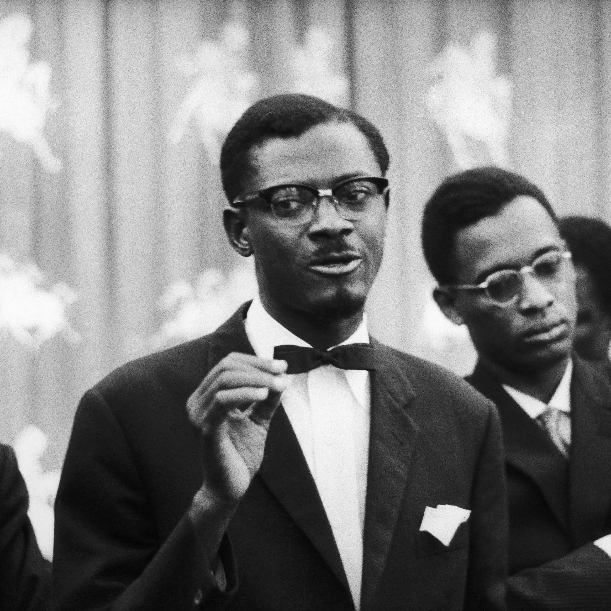 A man bespactacled man wearing a bow tie speaks to an audience.