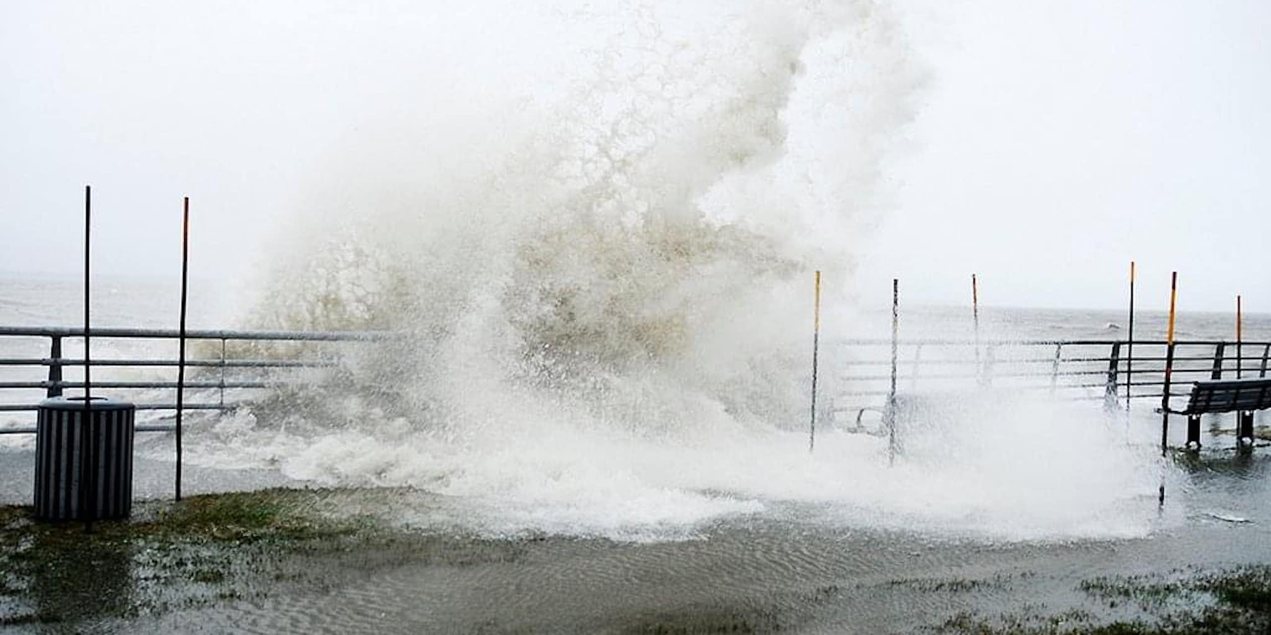 grande vague déferlant sur une promenade au bord de la mer