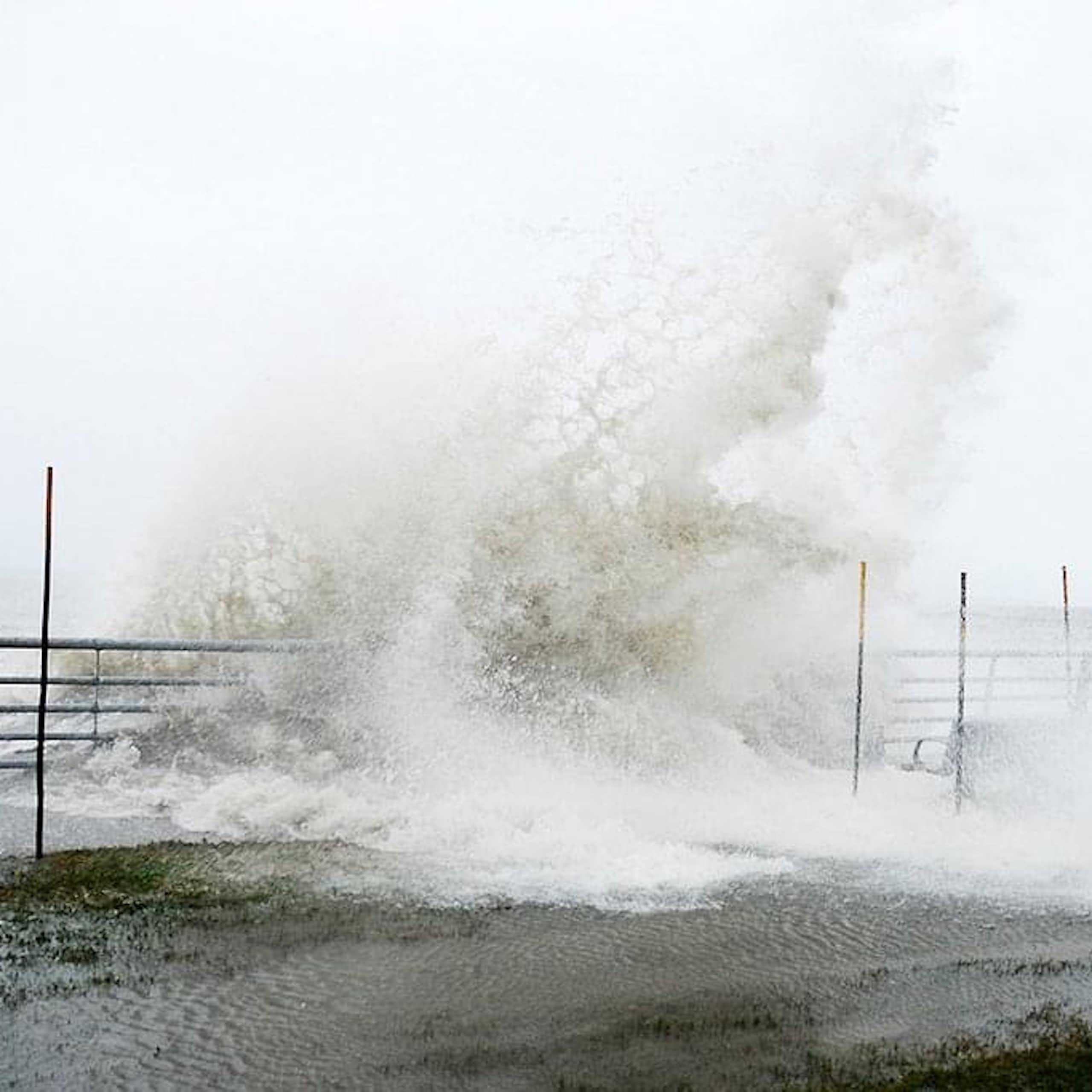 grande vague déferlant sur une promenade au bord de la mer