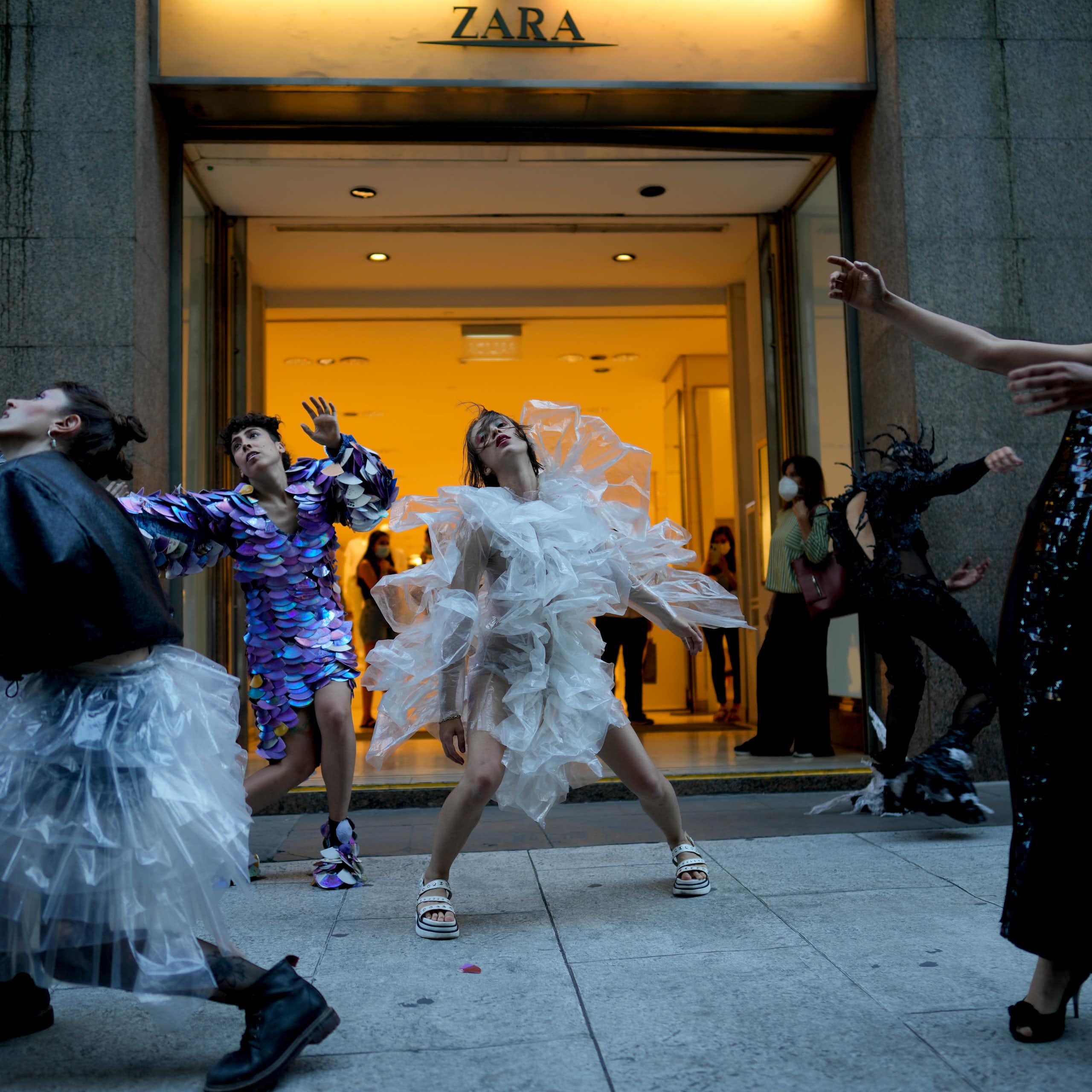 People dance in front of a store front.