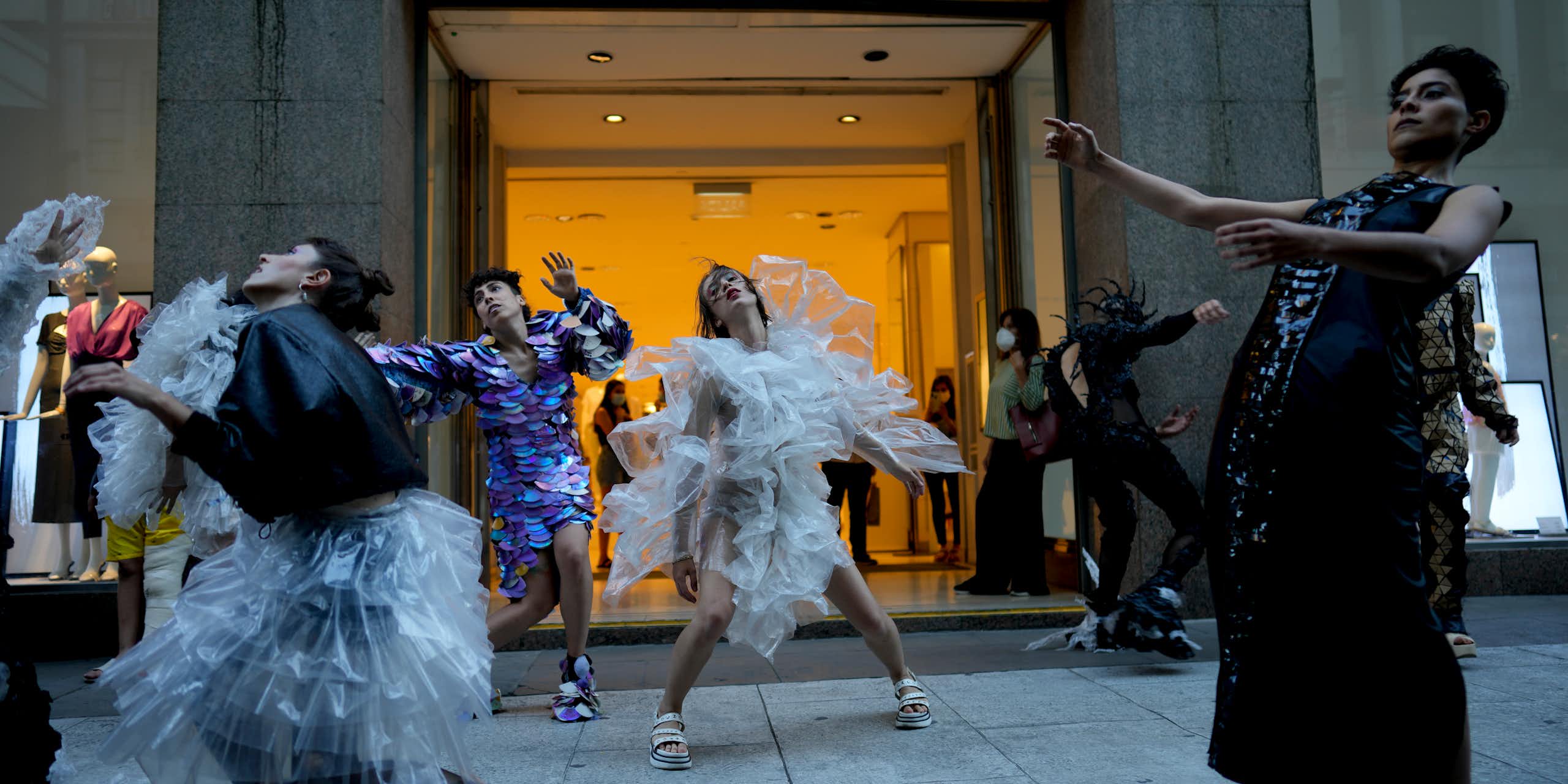 Des personnes dansent devant la devanture d'un magasin.