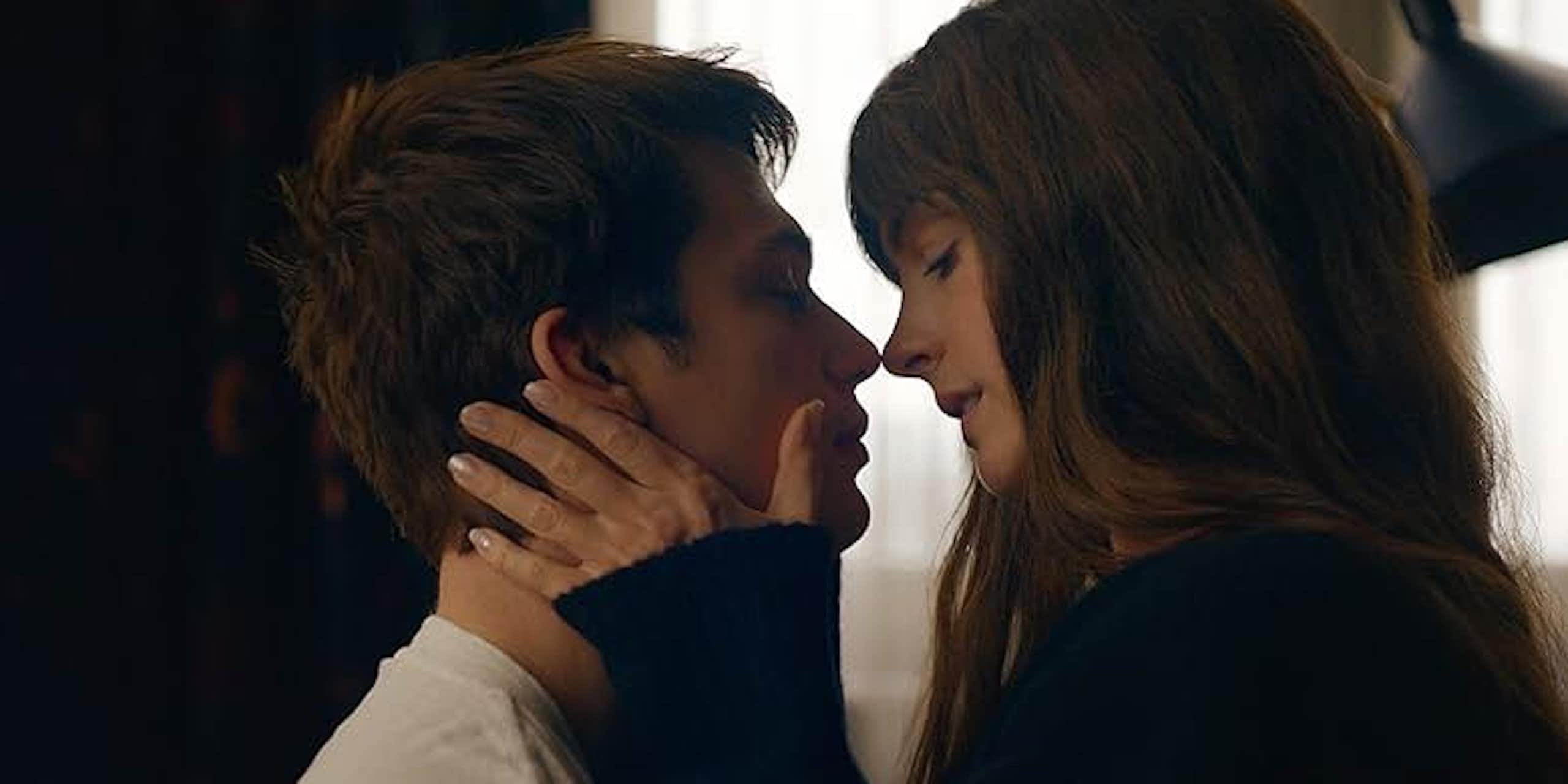 A man and woman embrace and lean in for a kiss