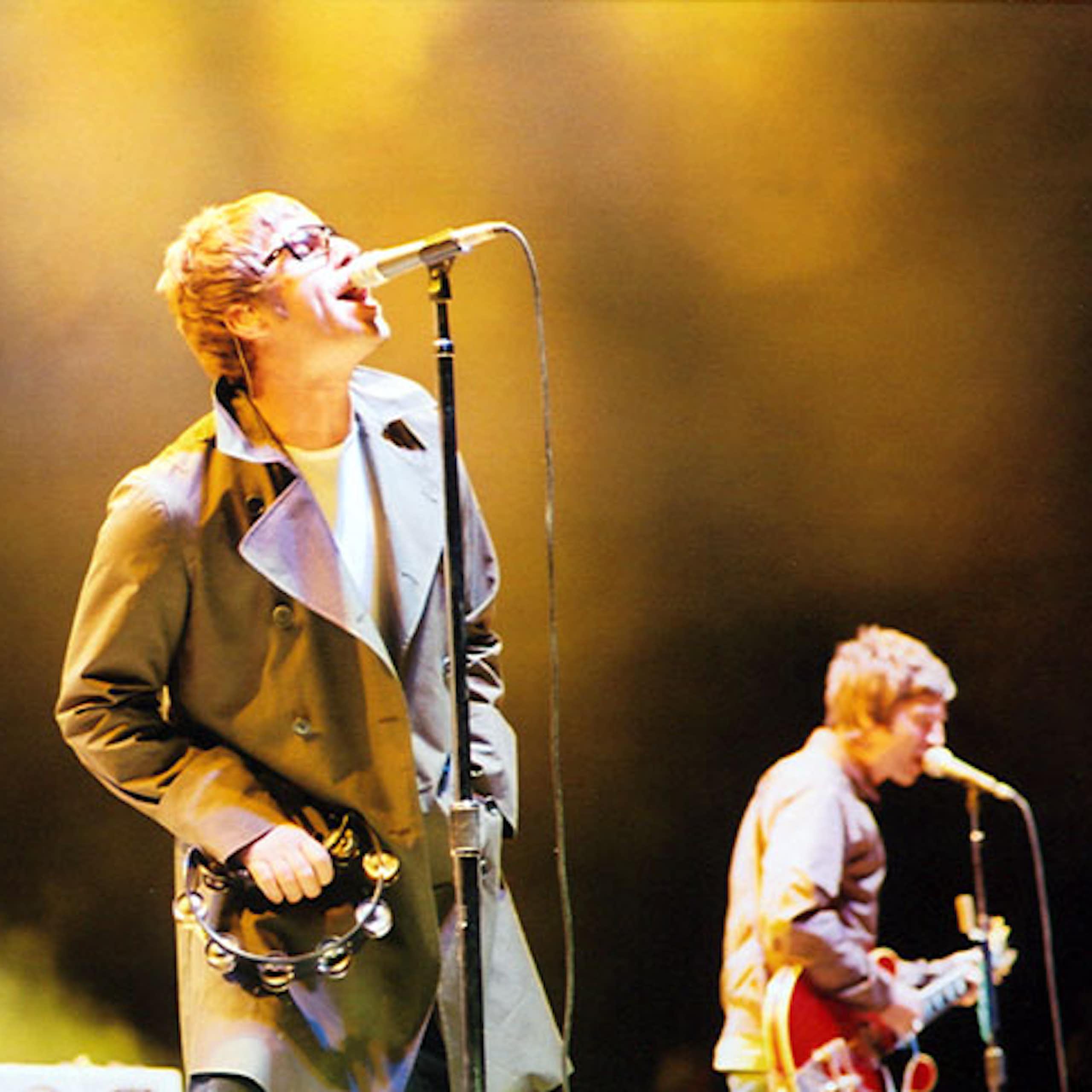 Two musicians on a stage, one singing, the other playing guitar.