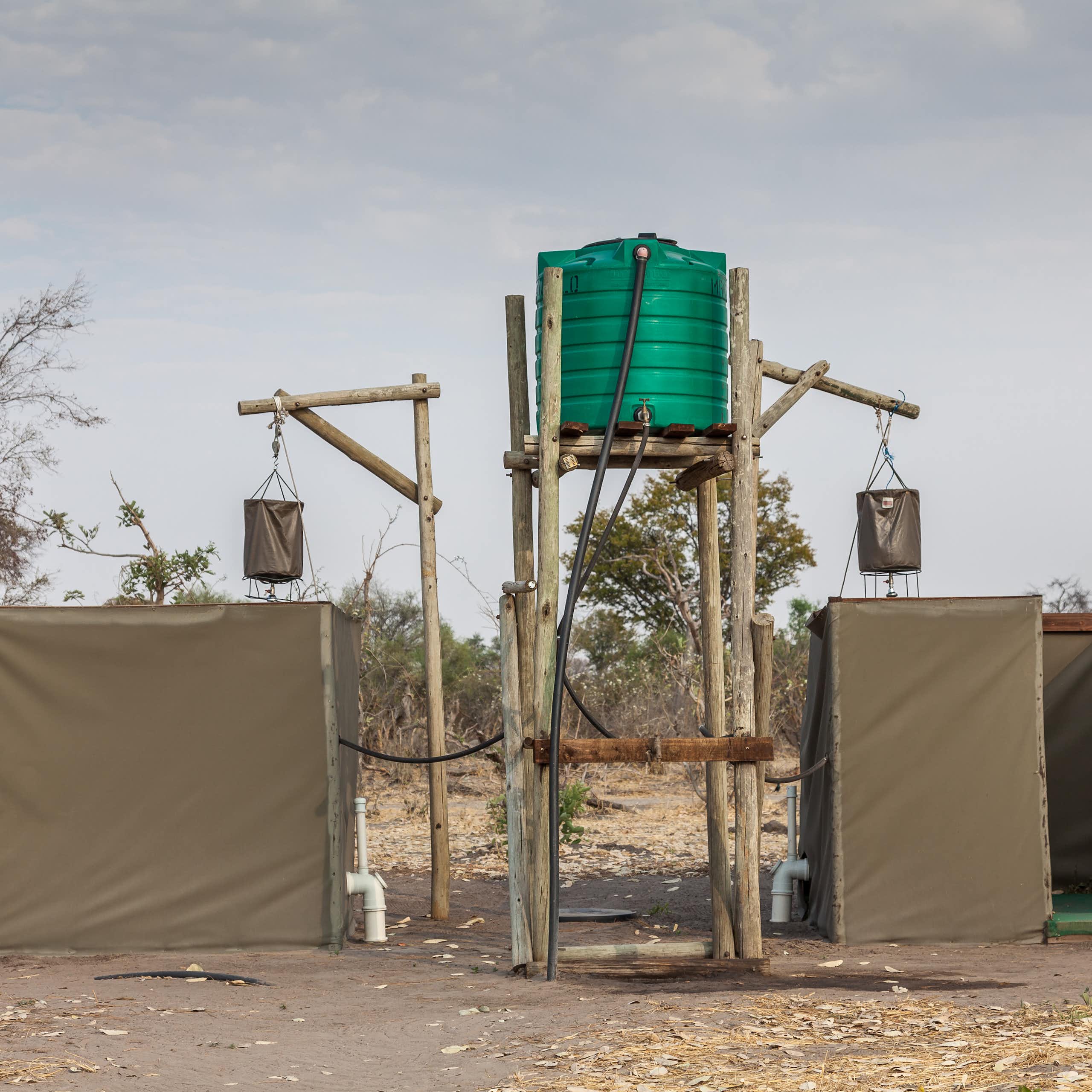 Eco-friendly outdoor showers with a bucket hung up high and linked to a water tank