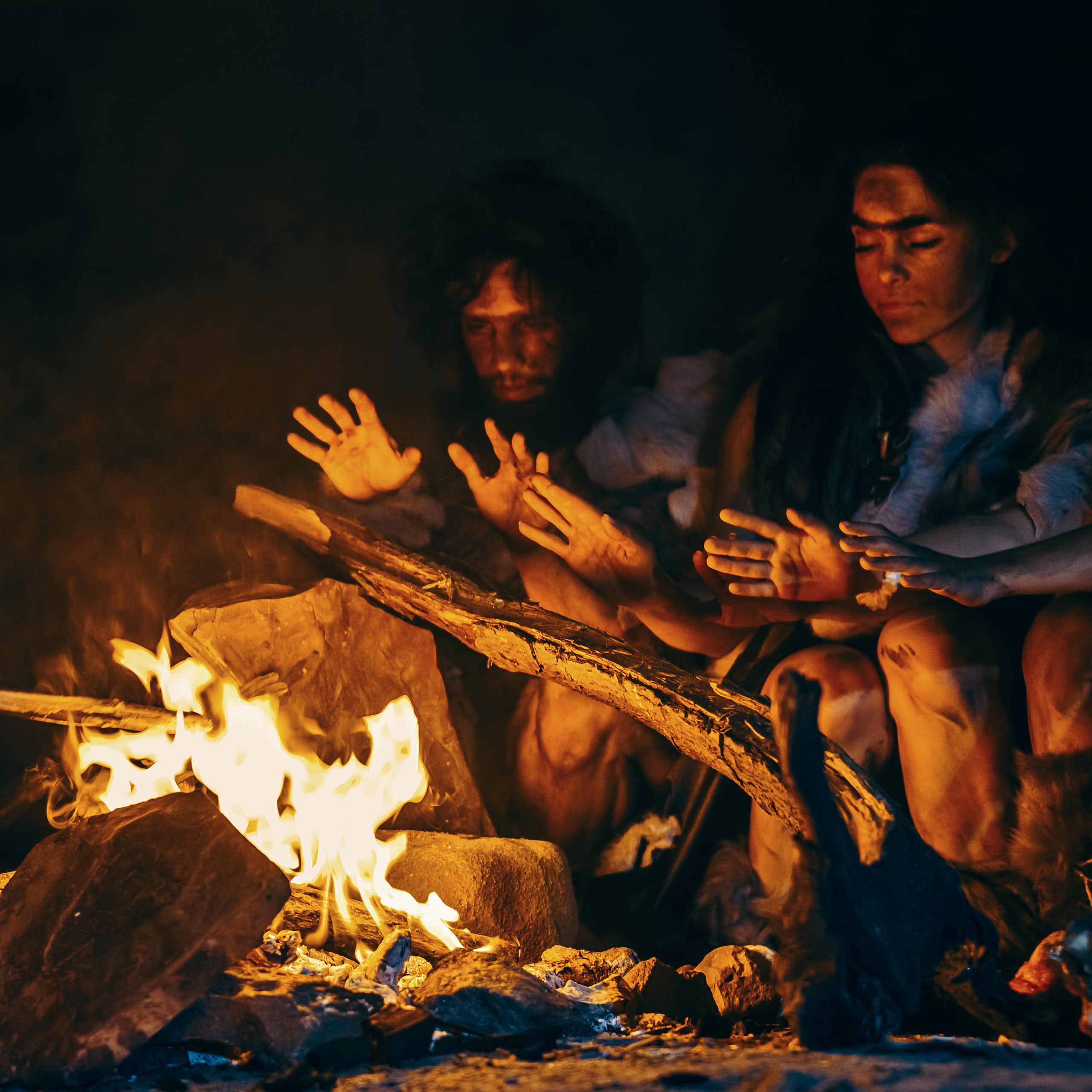 Reconstitution d'une famille très ancienne devant un feu.