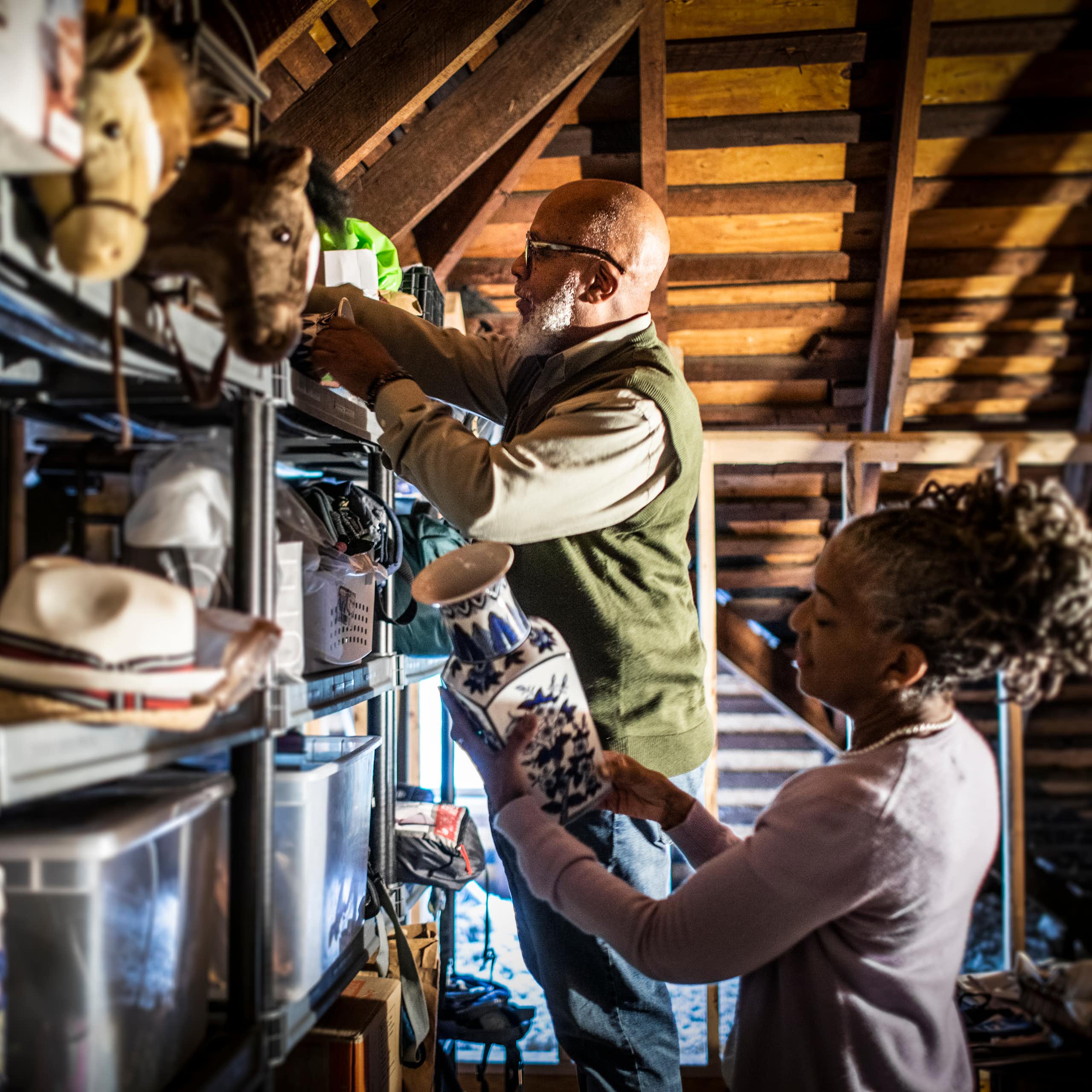 Casal de idosos organizando itens no sótão da casa