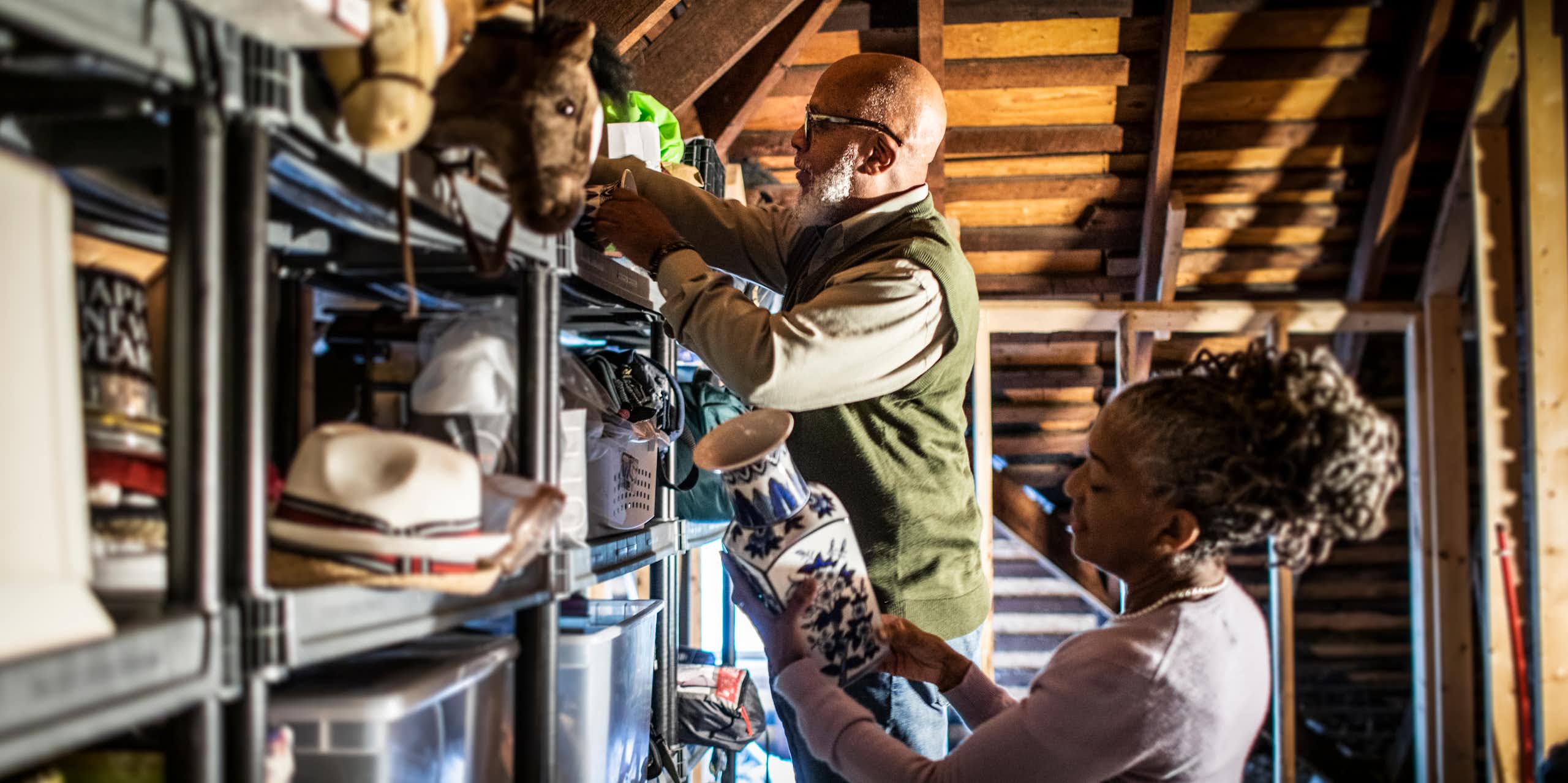 Casal de idosos organizando itens no sótão da casa