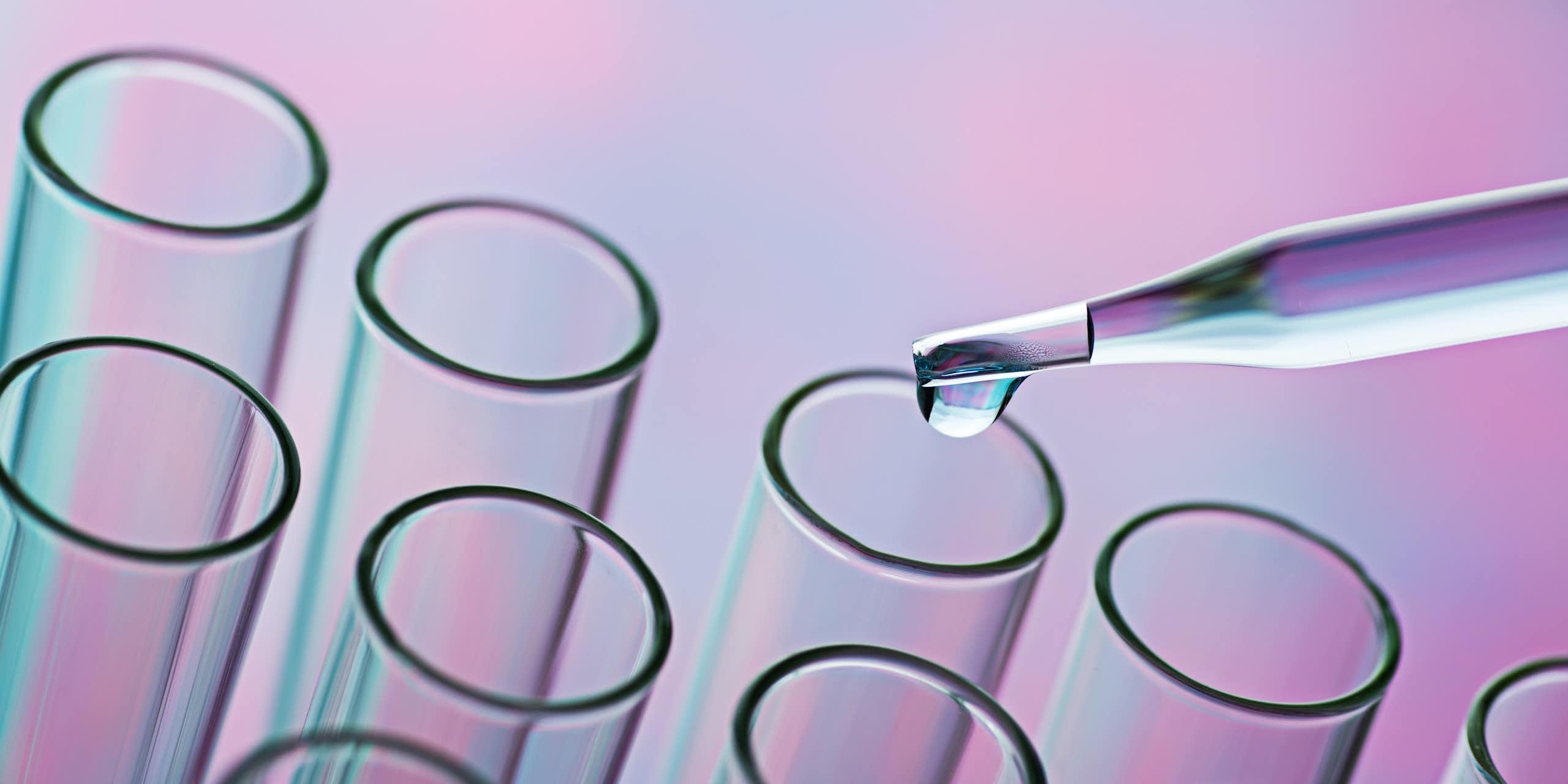Glass pipette distributing liquid into test tubes. 