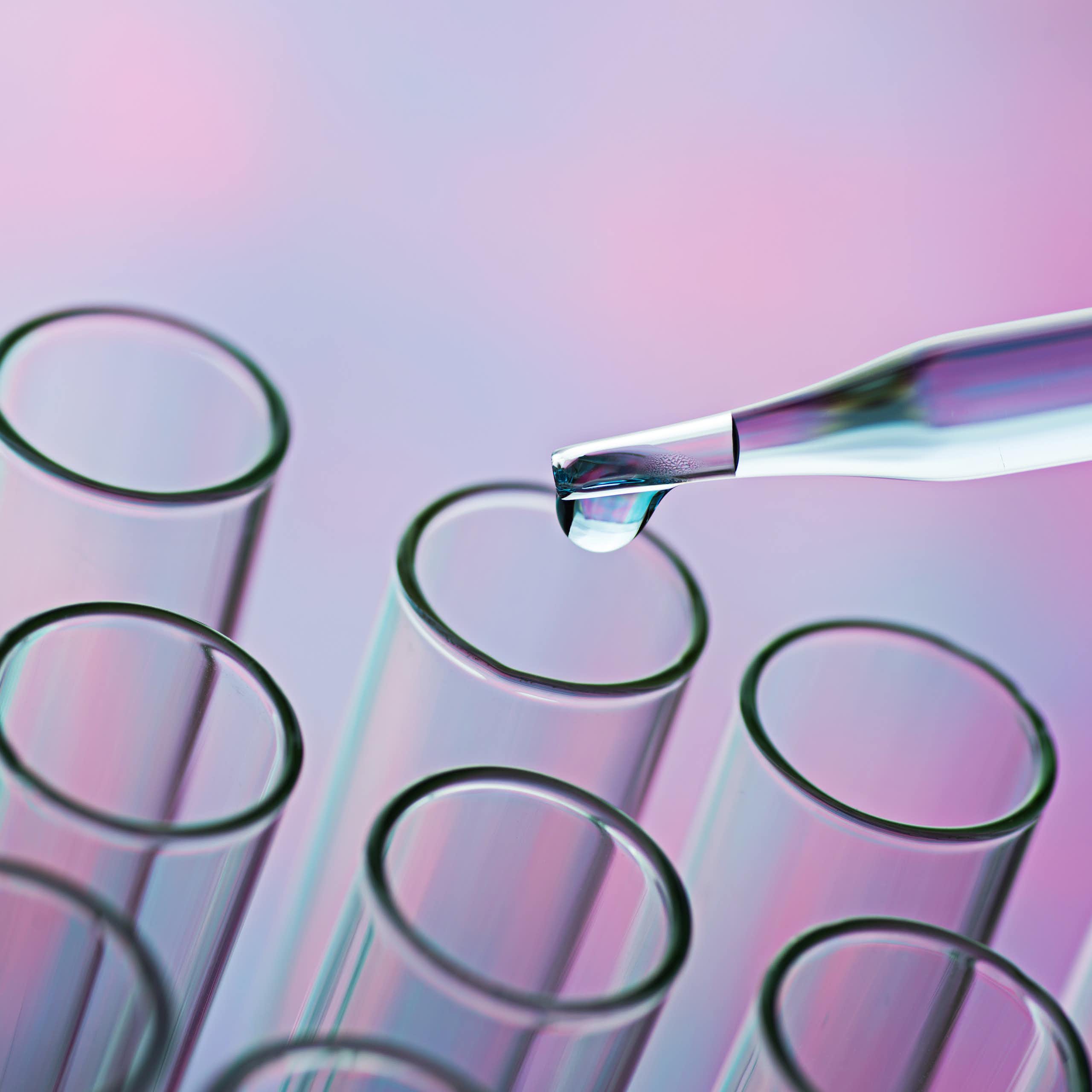 Glass pipette distributing liquid into test tubes.