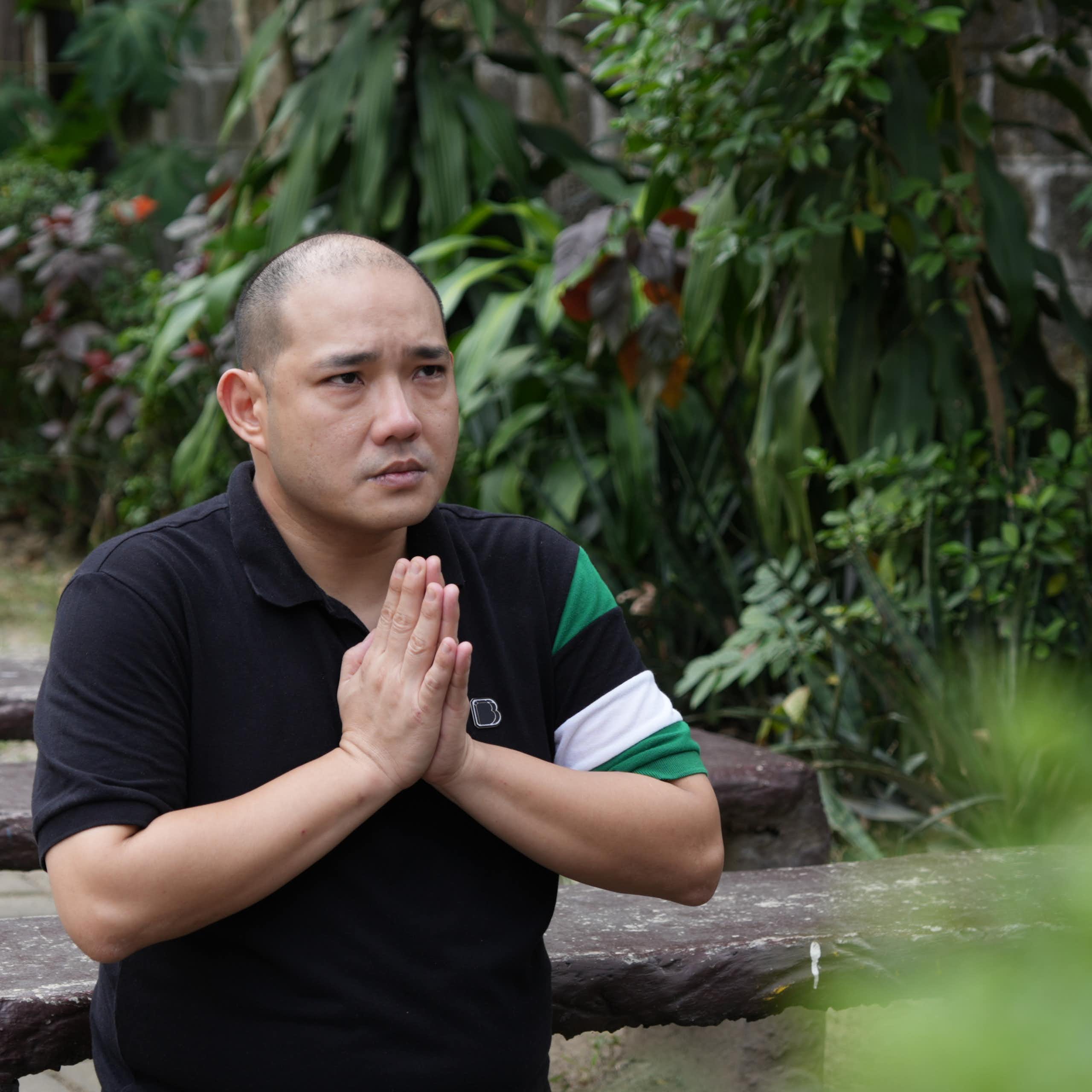 A man who was trafficked to a compound praying. 