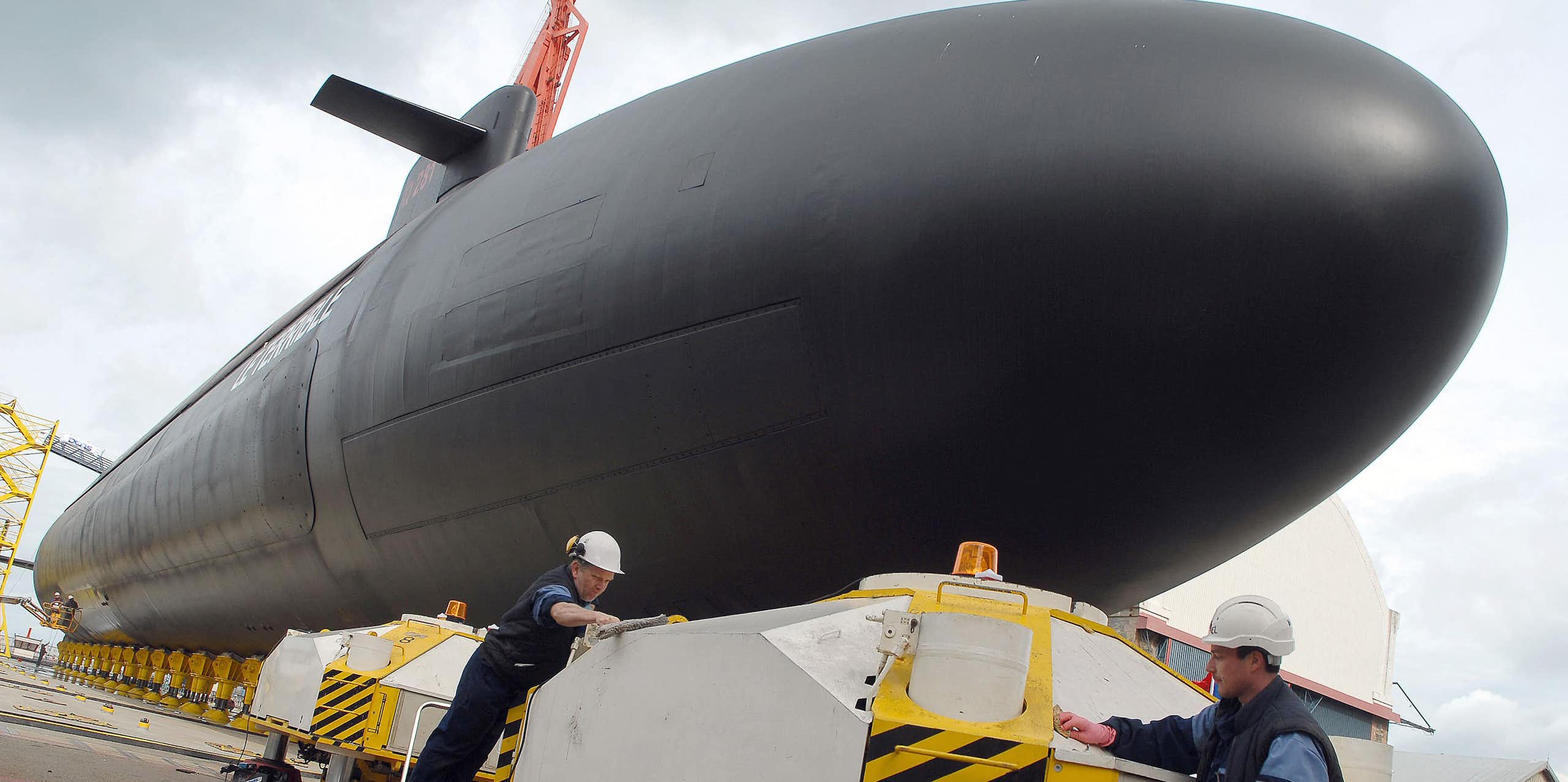 image d'un sous-marin à quai et des ouvriers