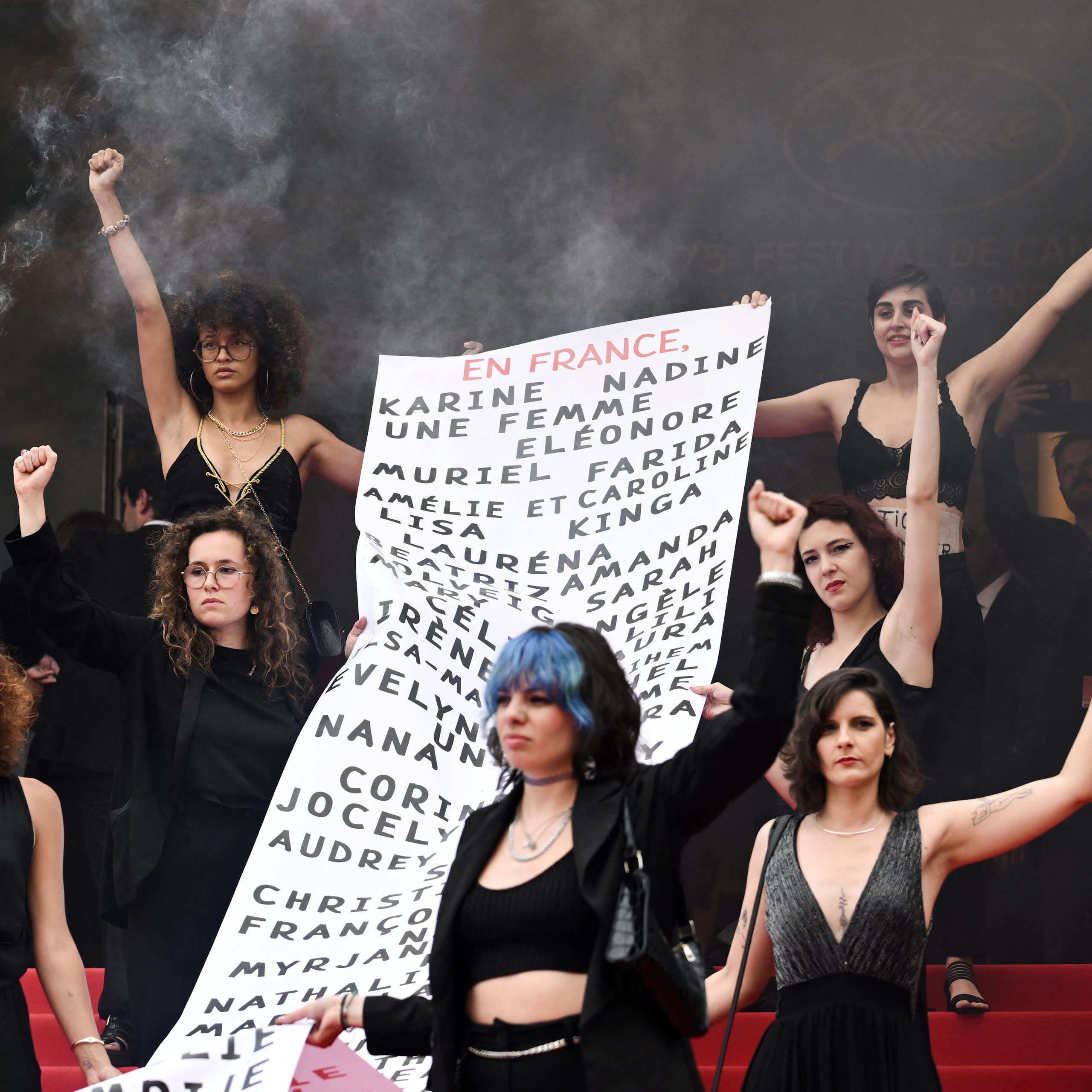 au Festival de Cannes en 2022, des membres du mouvement féministe « Les Colleuses » tiennent une banderole portant les noms de 129 victimes de féminicides.