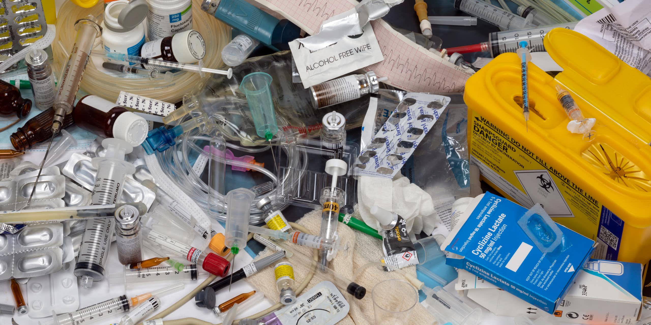 A collection of used, single-use medical plastic items — such as syringes, wipes, medicine containers and gloves.