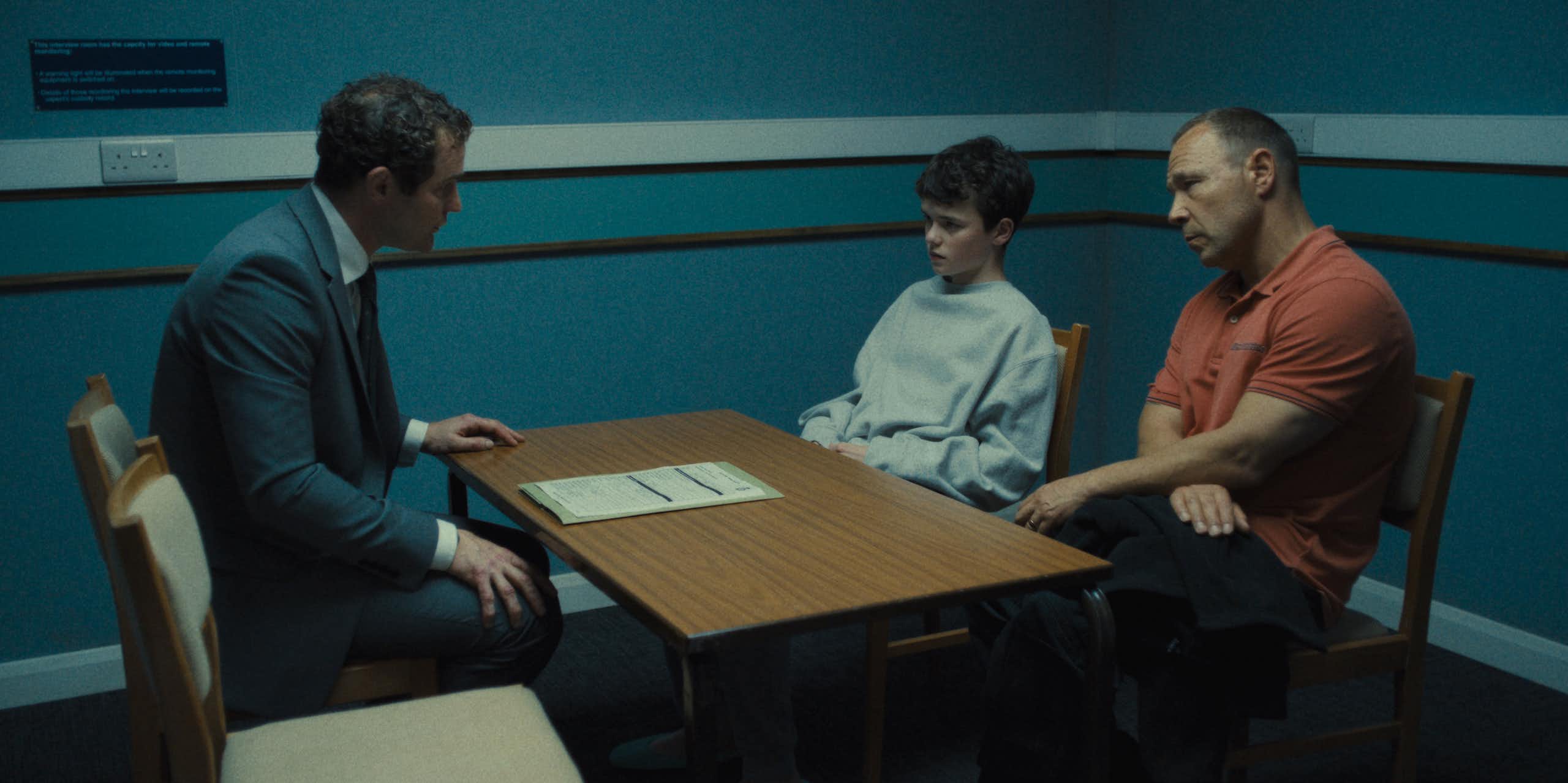 Um menino e seu pai sentaram-se em uma sala de interrogatório com um detetive