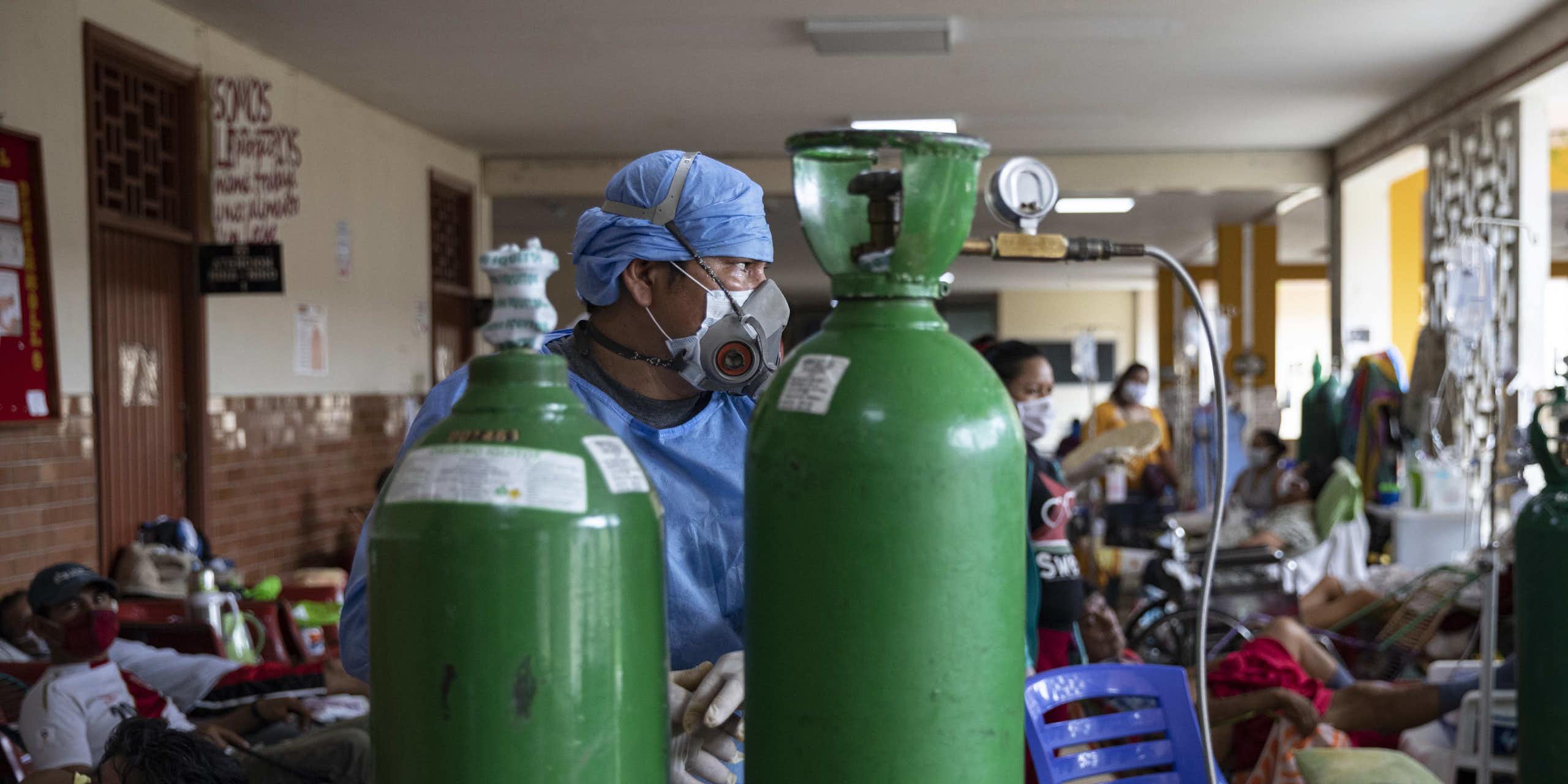 A doctor in front of two oxygen tanks in Iquitos, Peru.