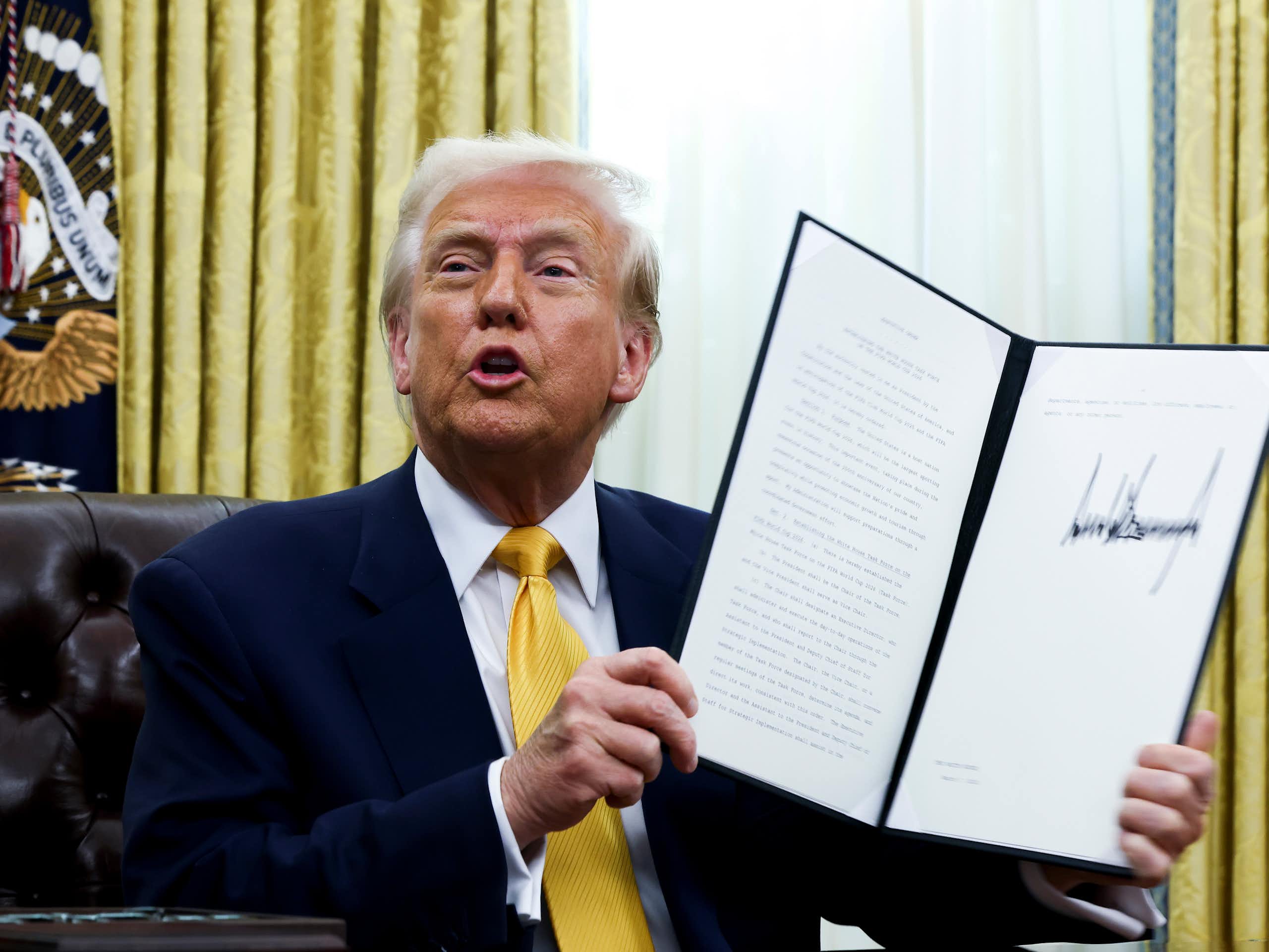 Donald Trump tenant un document à la main