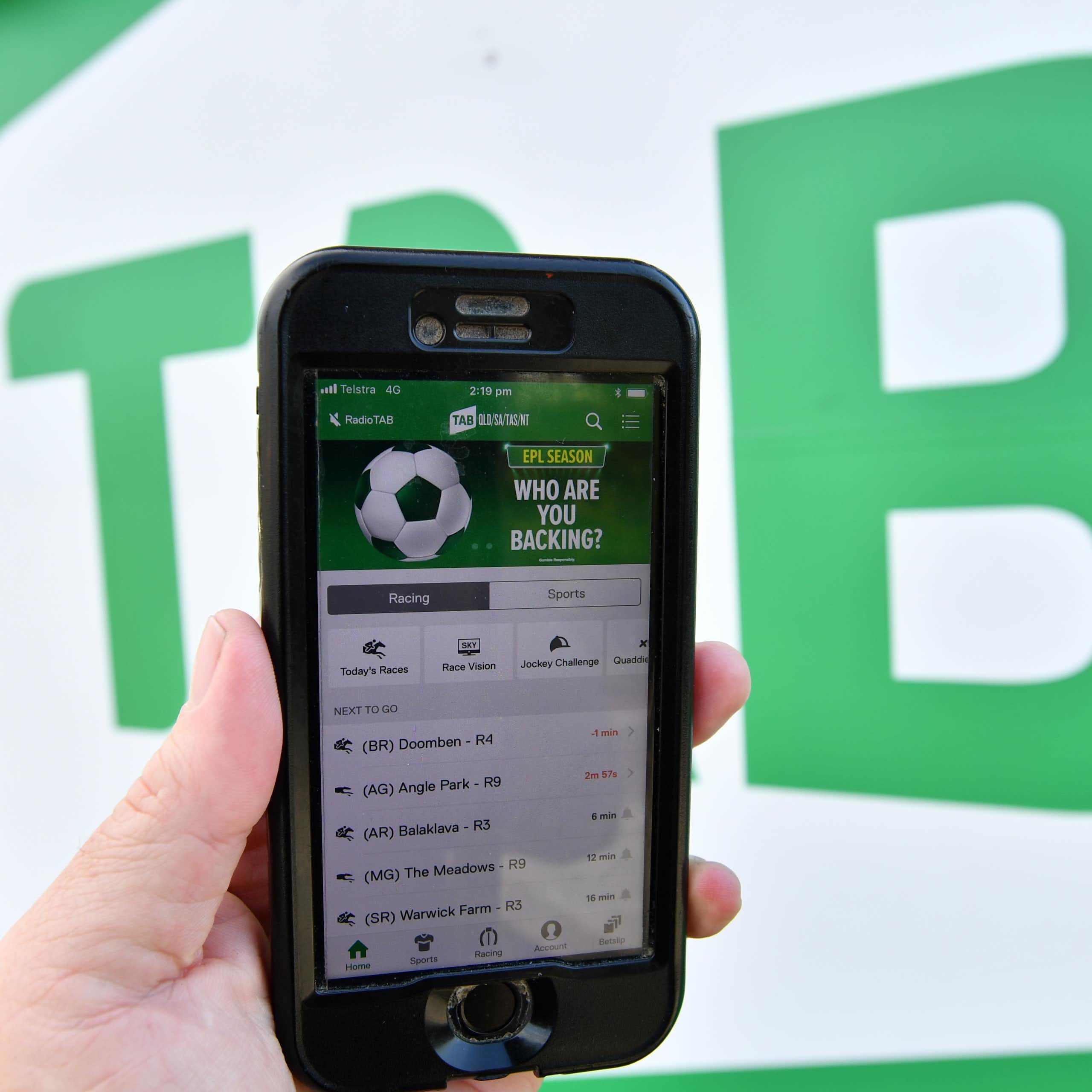 The TAB betting app is seen on a mobile phone outside a Tabcorp venue