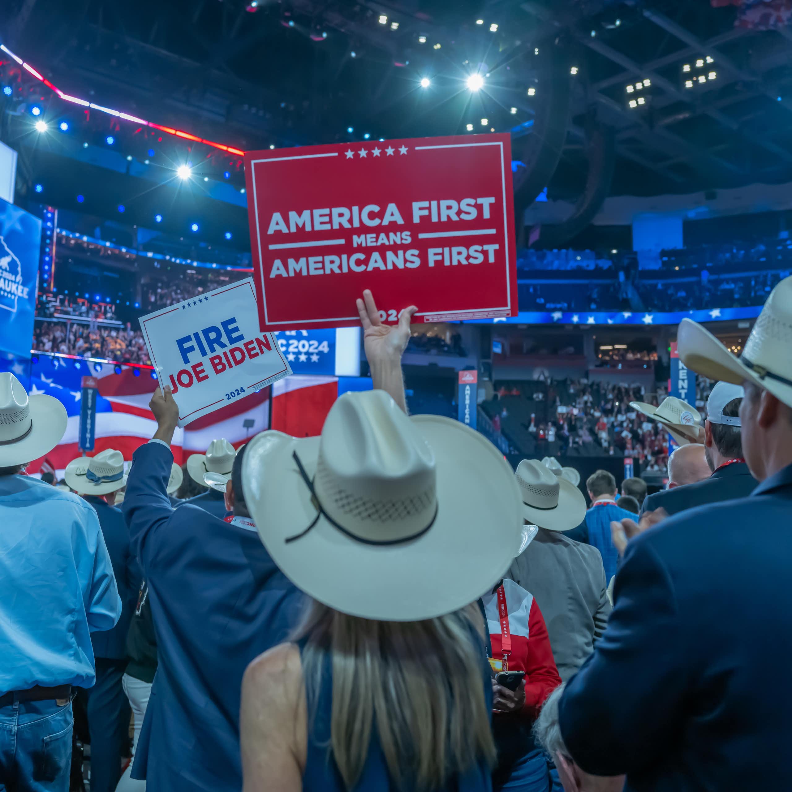 delegates at a trump rally in 2024 hold an America First sign