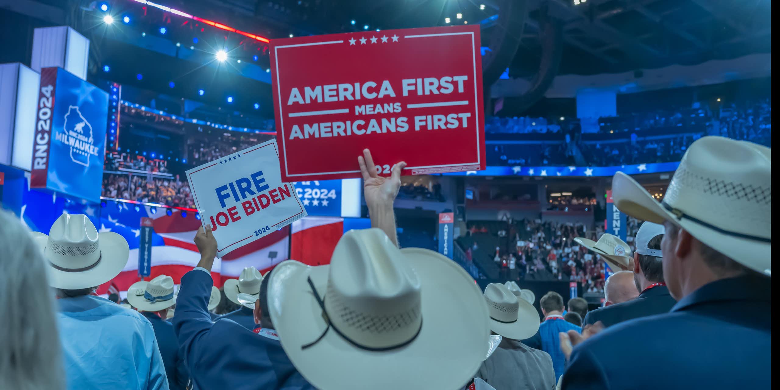 delegates at a trump rally in 2024 hold an America First sign