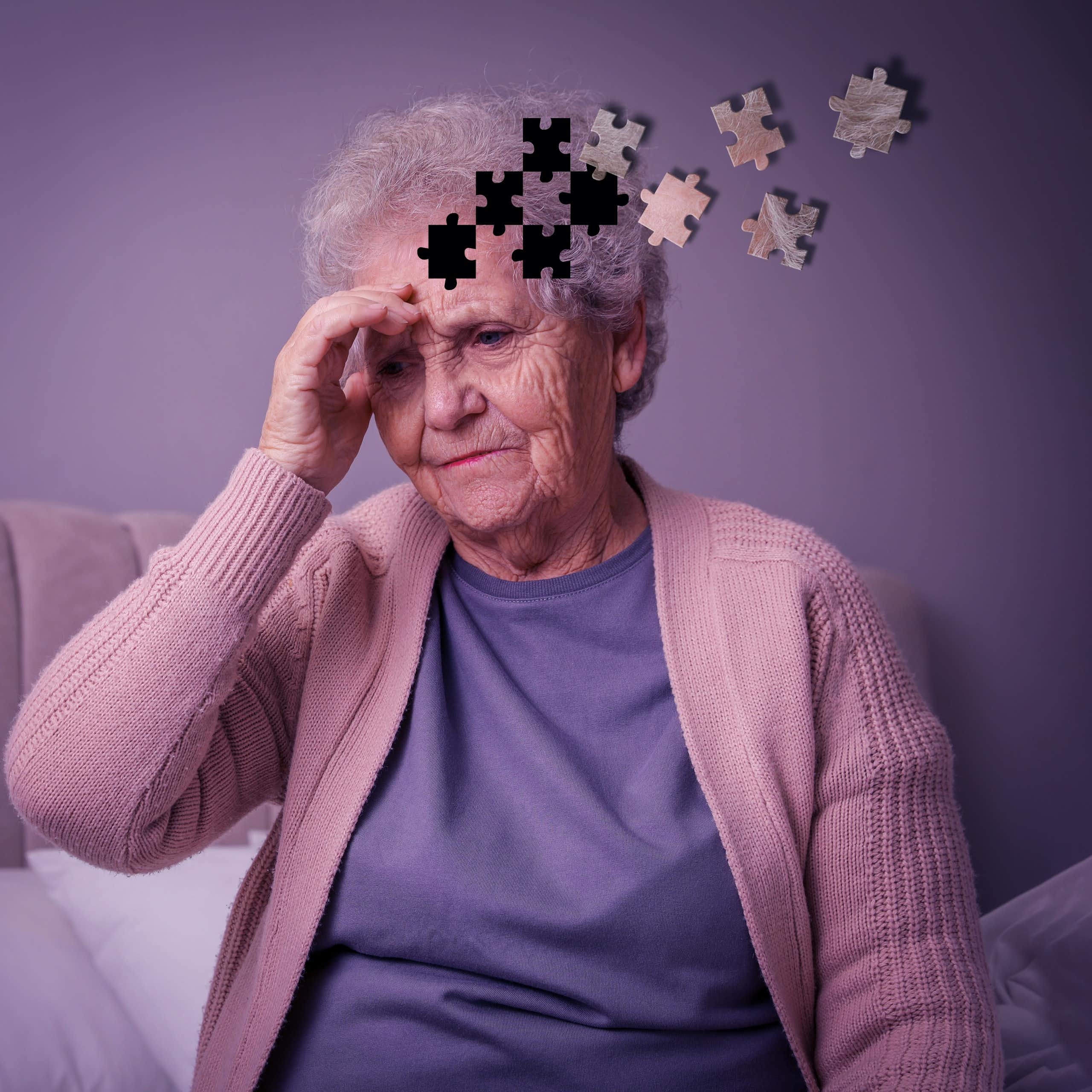 Mulher idosa segurando a cabeça, parecendo preocupada