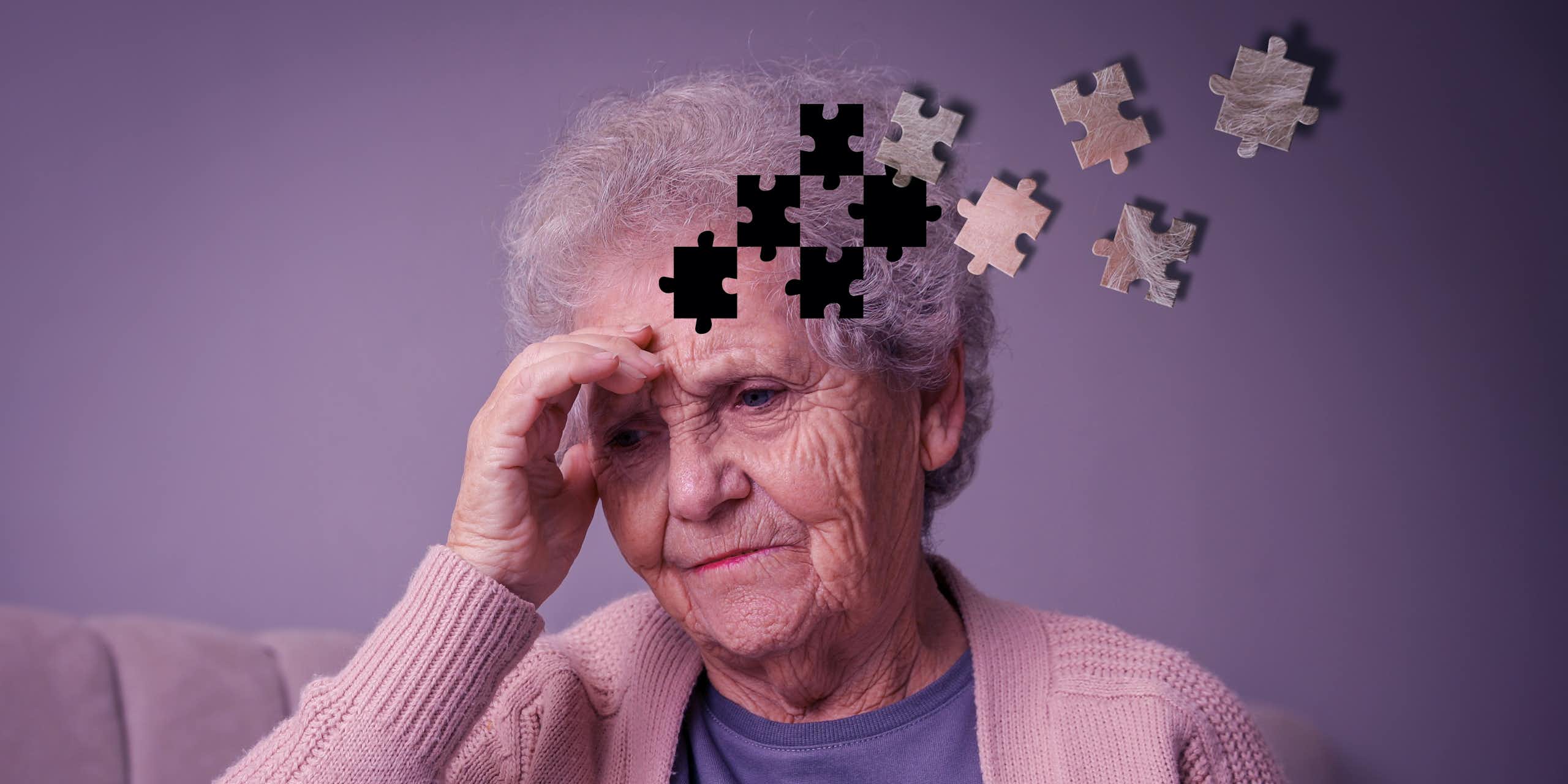 Mulher idosa segurando a cabeça, parecendo preocupada