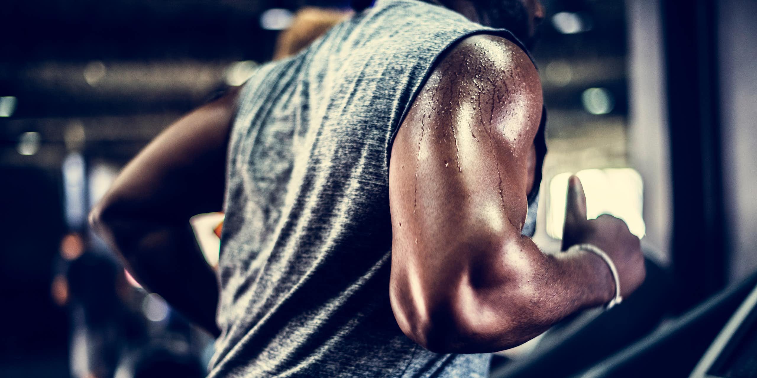 Man's torso sweating running on a treadmill.