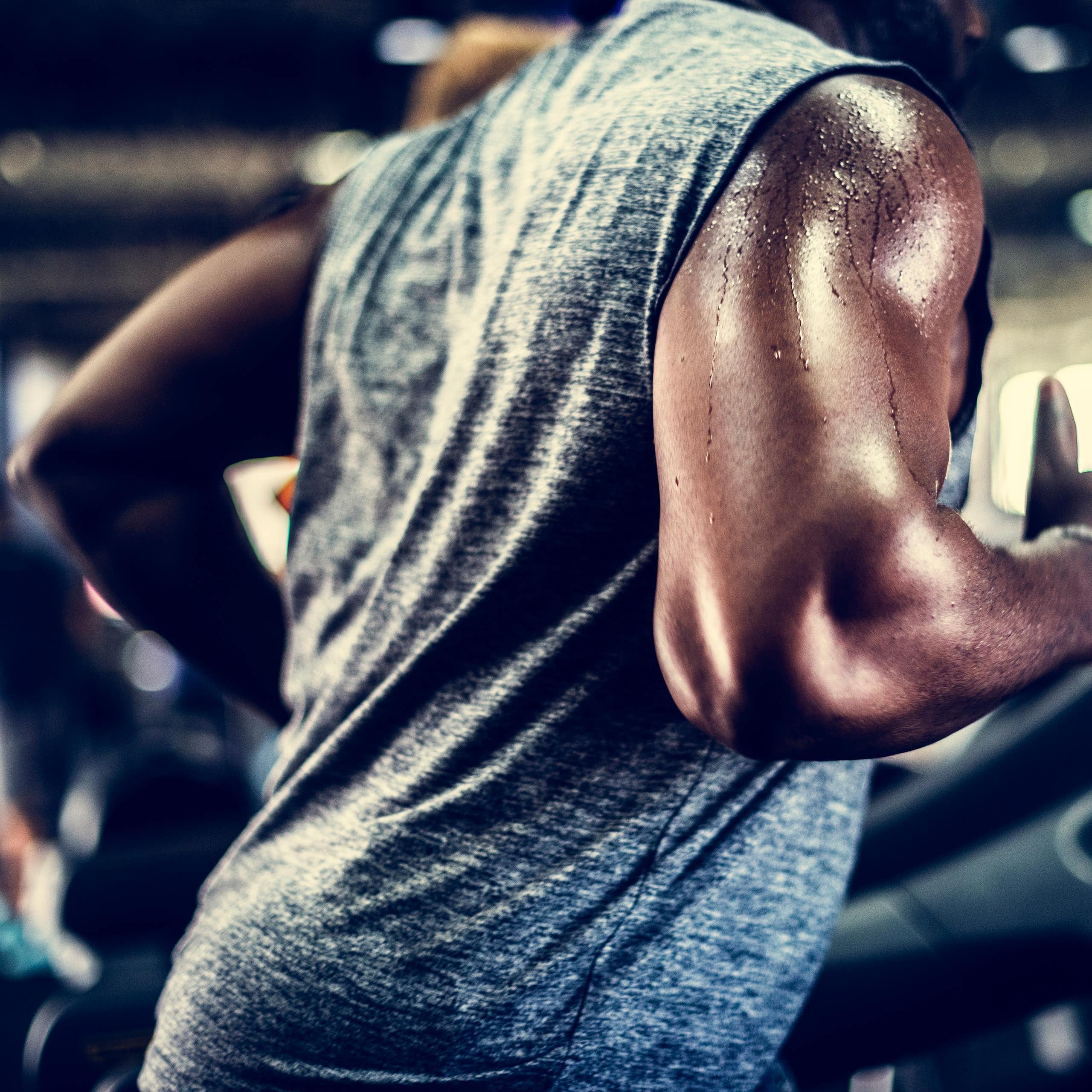 Man's torso sweating running on a treadmill.