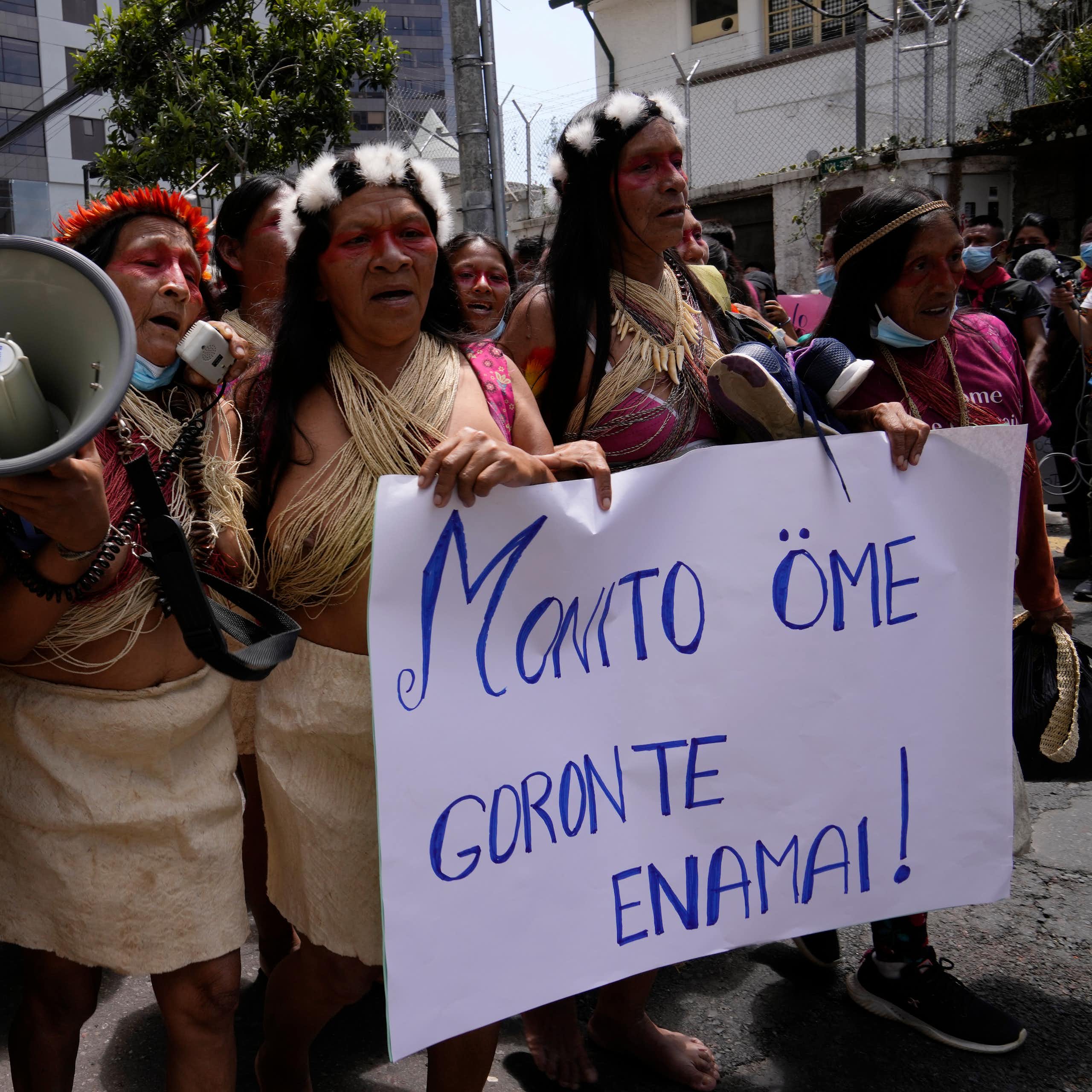 Indigenous people from the Amazon protests in the streets. They carry a sign that says: 'Our territory is not for sale,' which is written in Waorani.