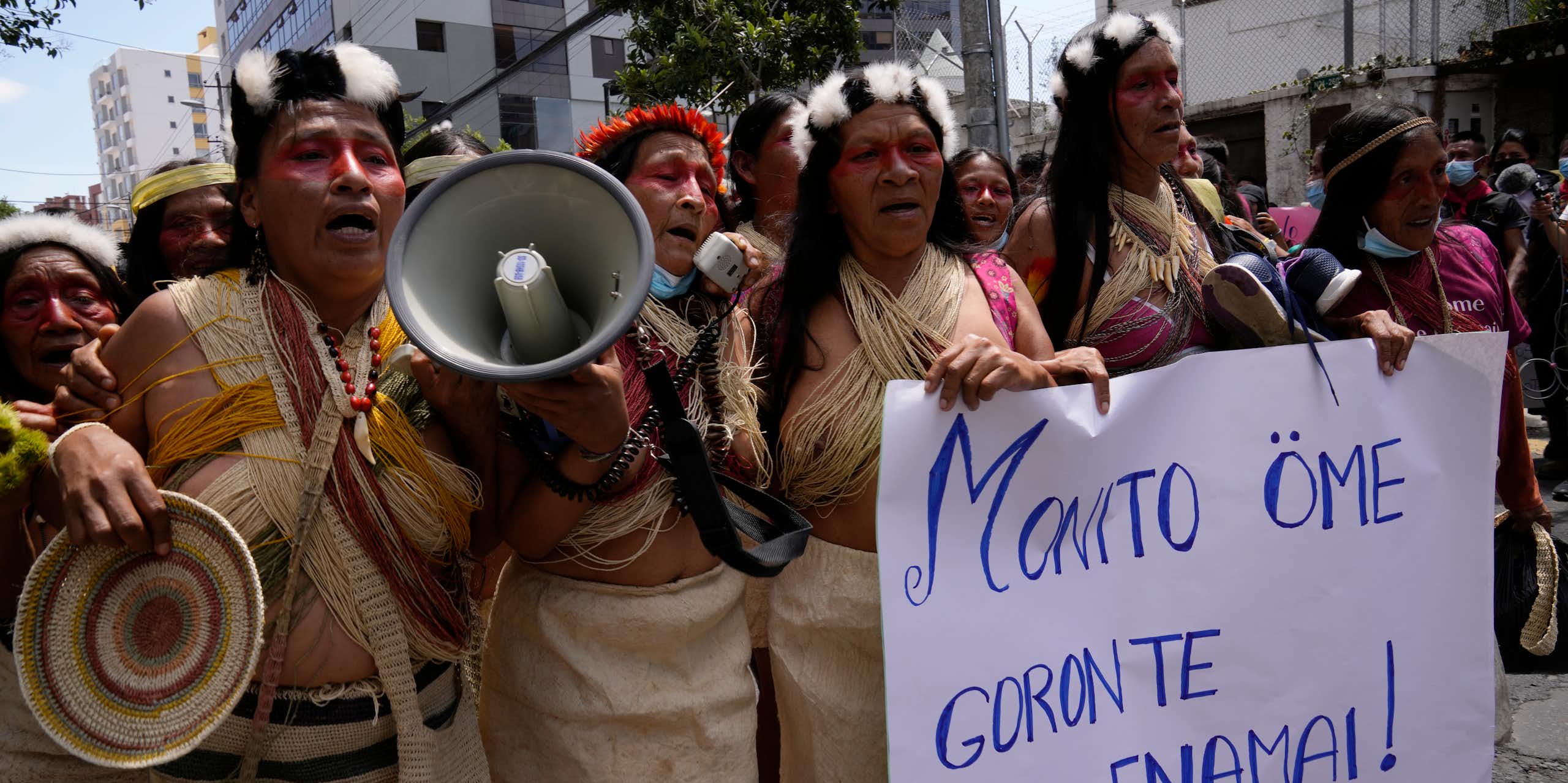 Indigenous people from the Amazon protests in the streets. They carry a sign that says: 'Our territory is not for sale,' which is written in Waorani.