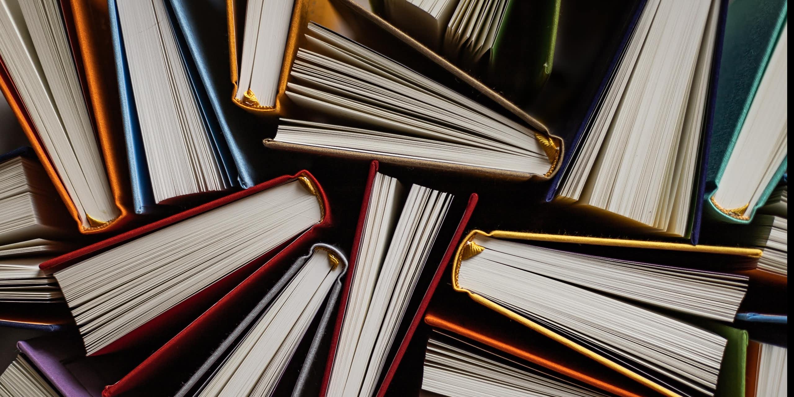 Top view of books with colourful covers opened on their side.  