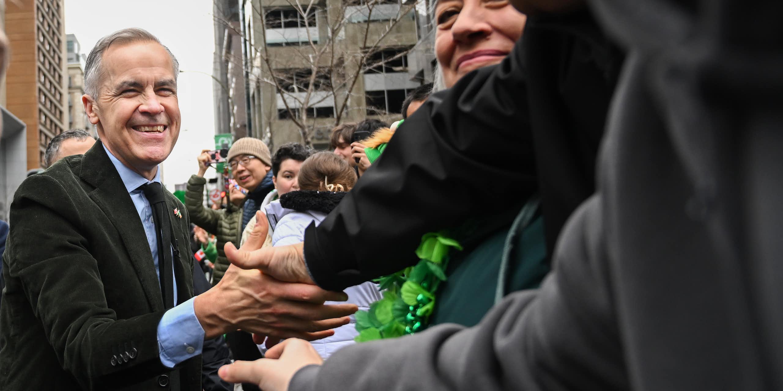 Un homme sourit à une foule.