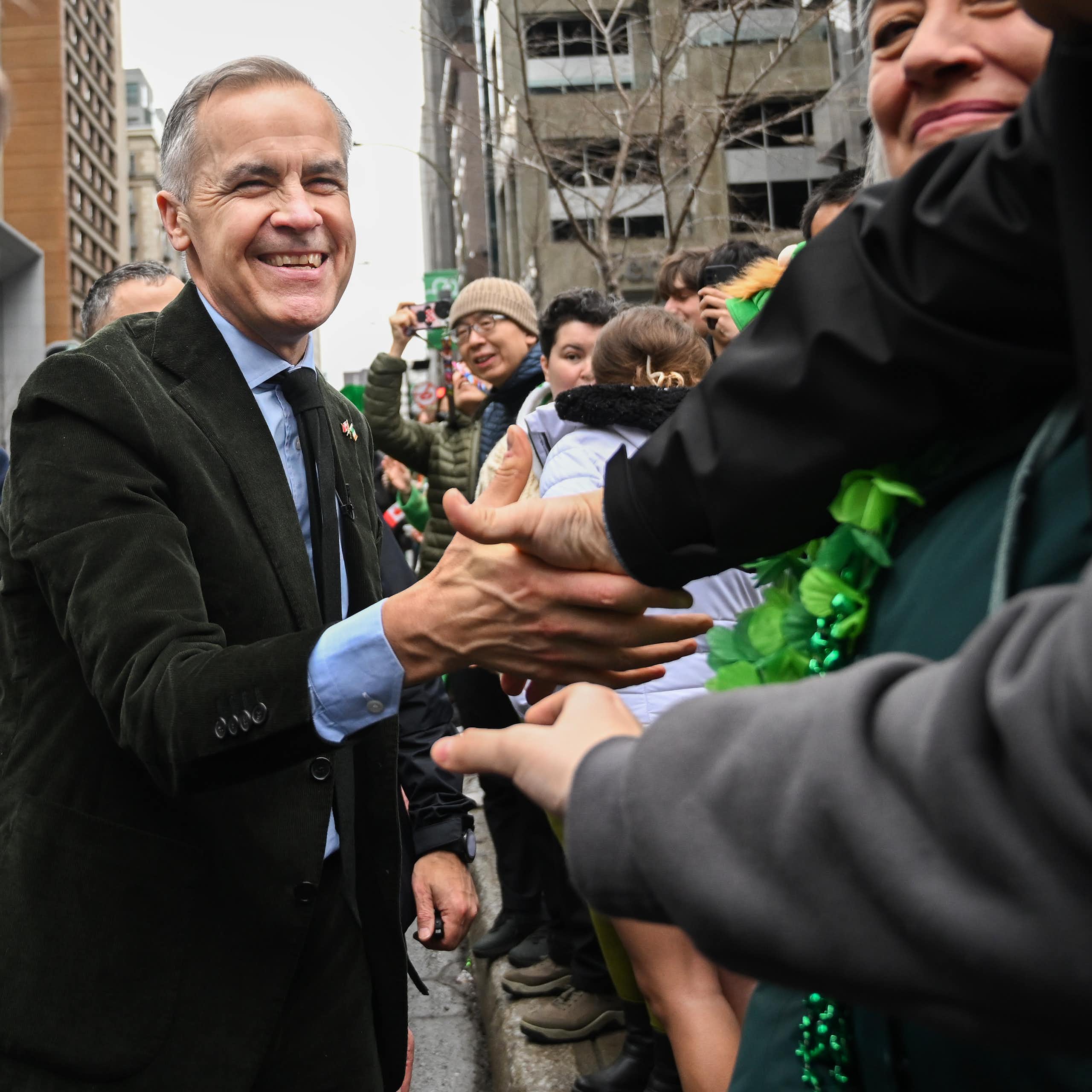Un homme sourit à une foule.