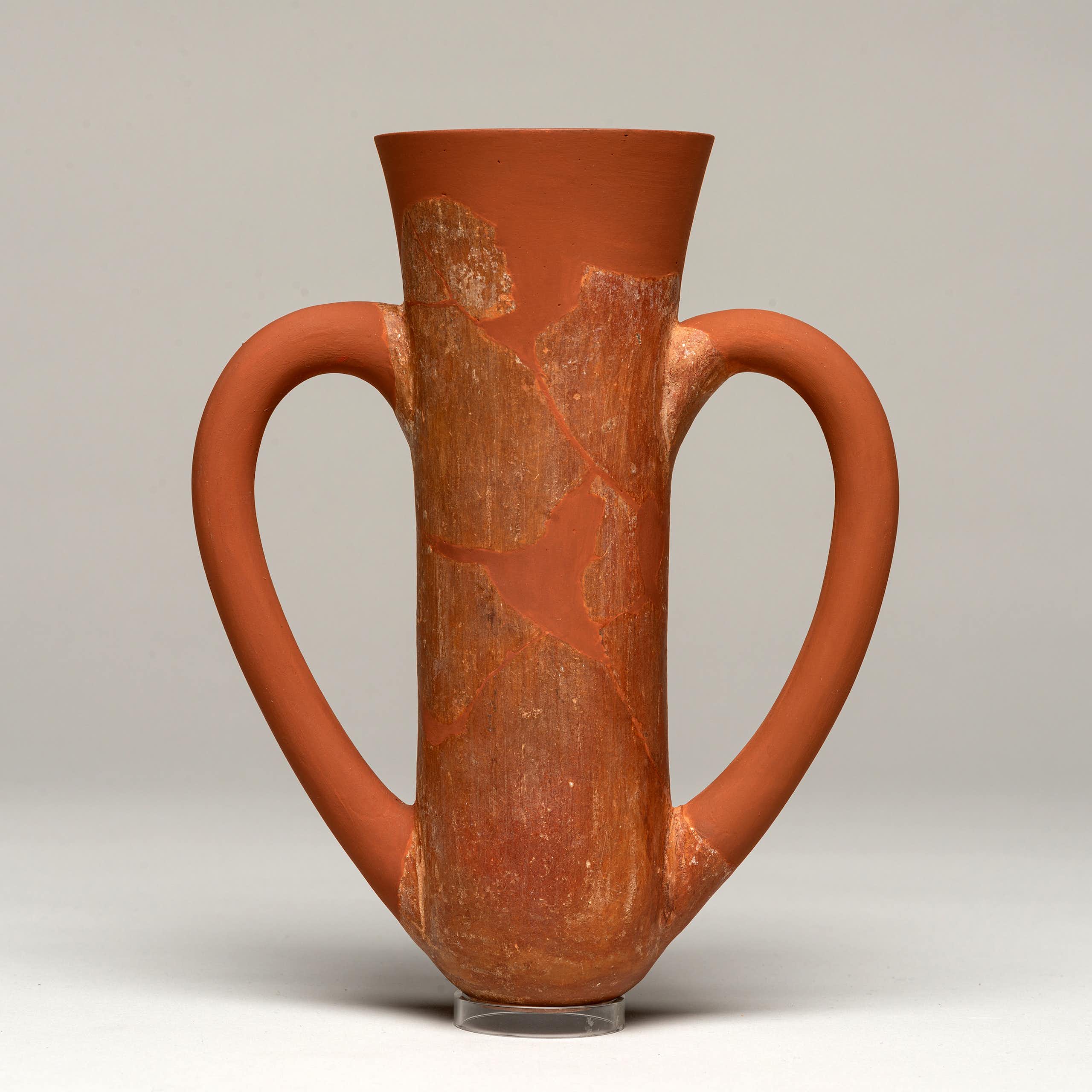 A terracota cup with two drinking handles