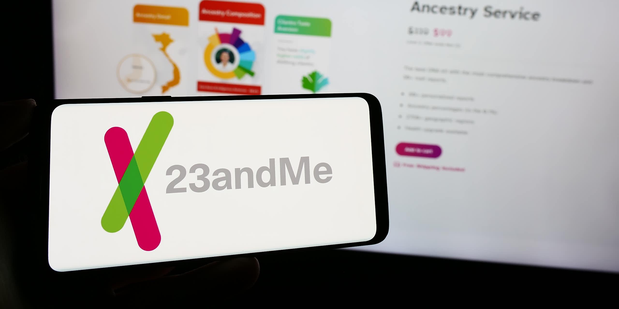 a computer screen and mobile phone screen both showing the 23andme logo and website