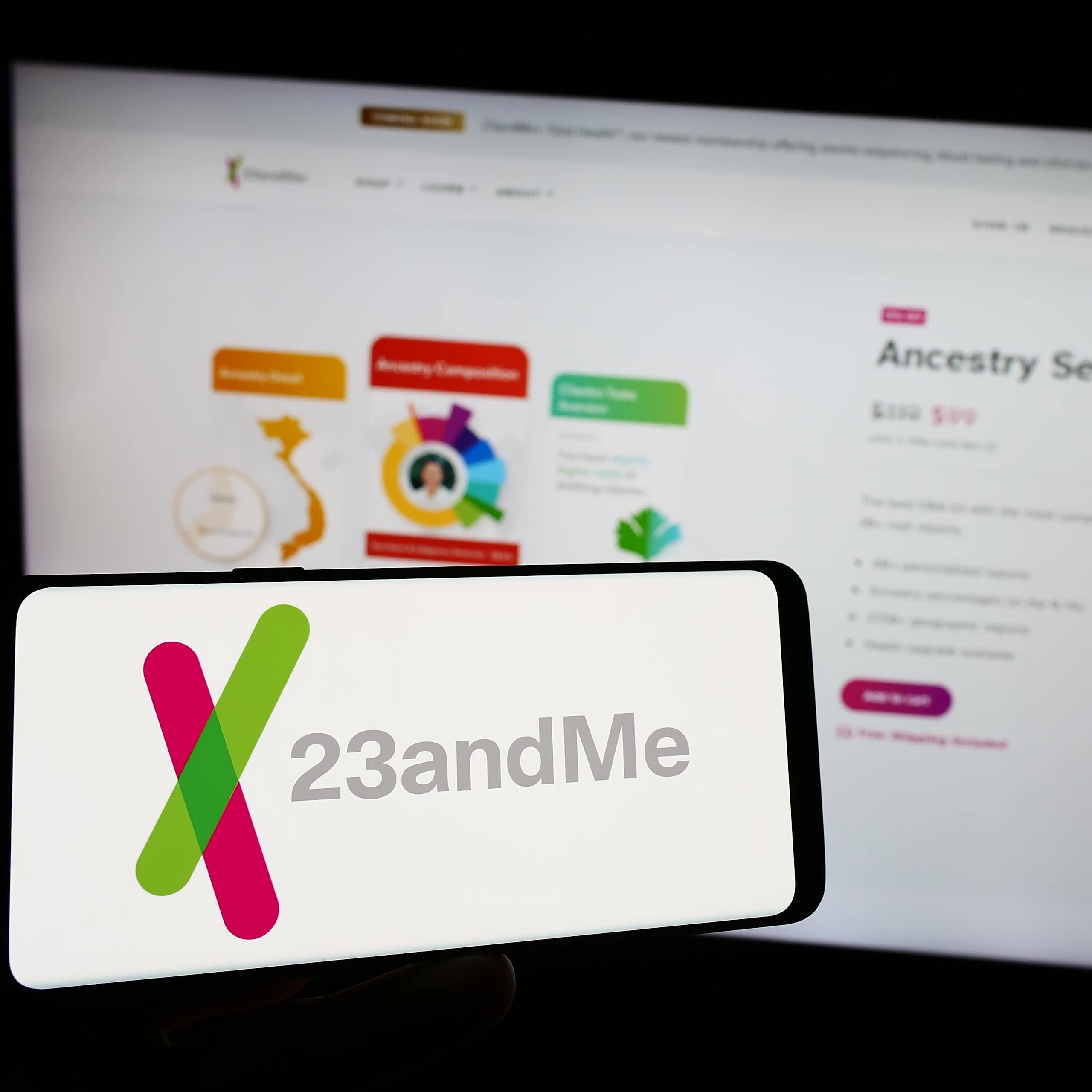 a computer screen and mobile phone screen both showing the 23andme logo and website