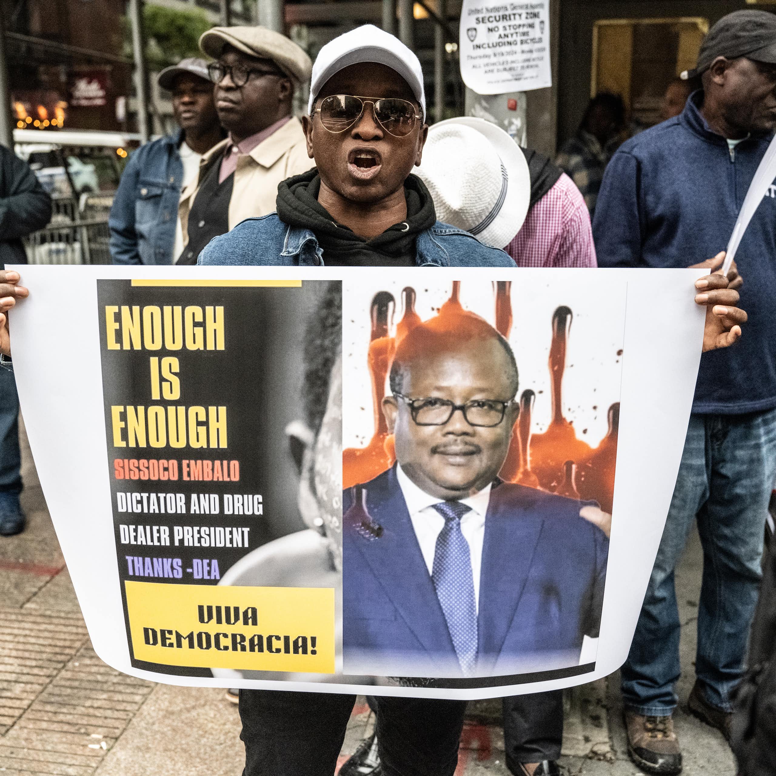 A man holds a placard with an image on it.