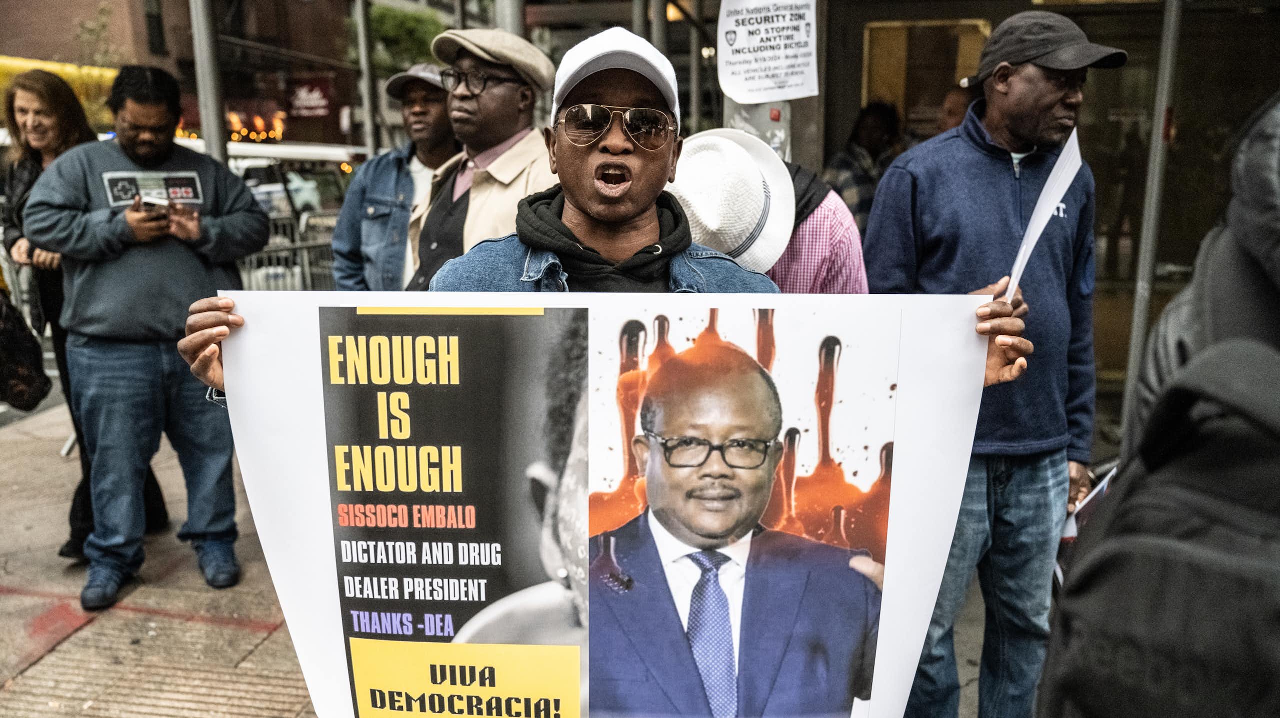 A man holds a placard with an image on it.