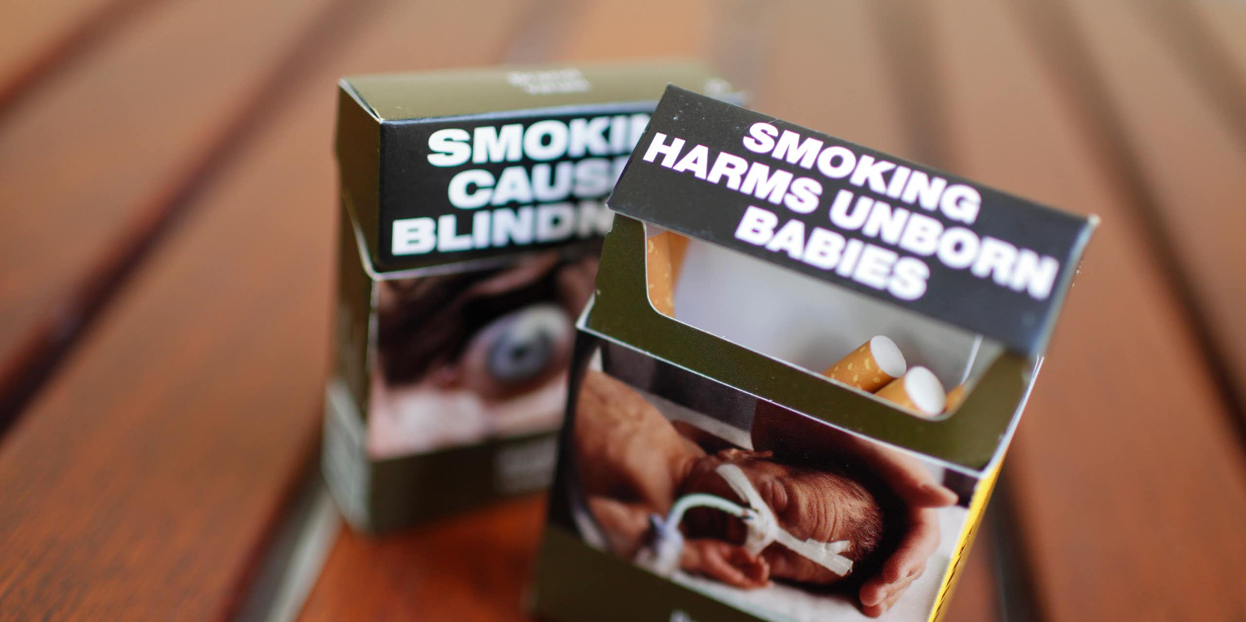 Two cigarette packs with plain packaging health warnings