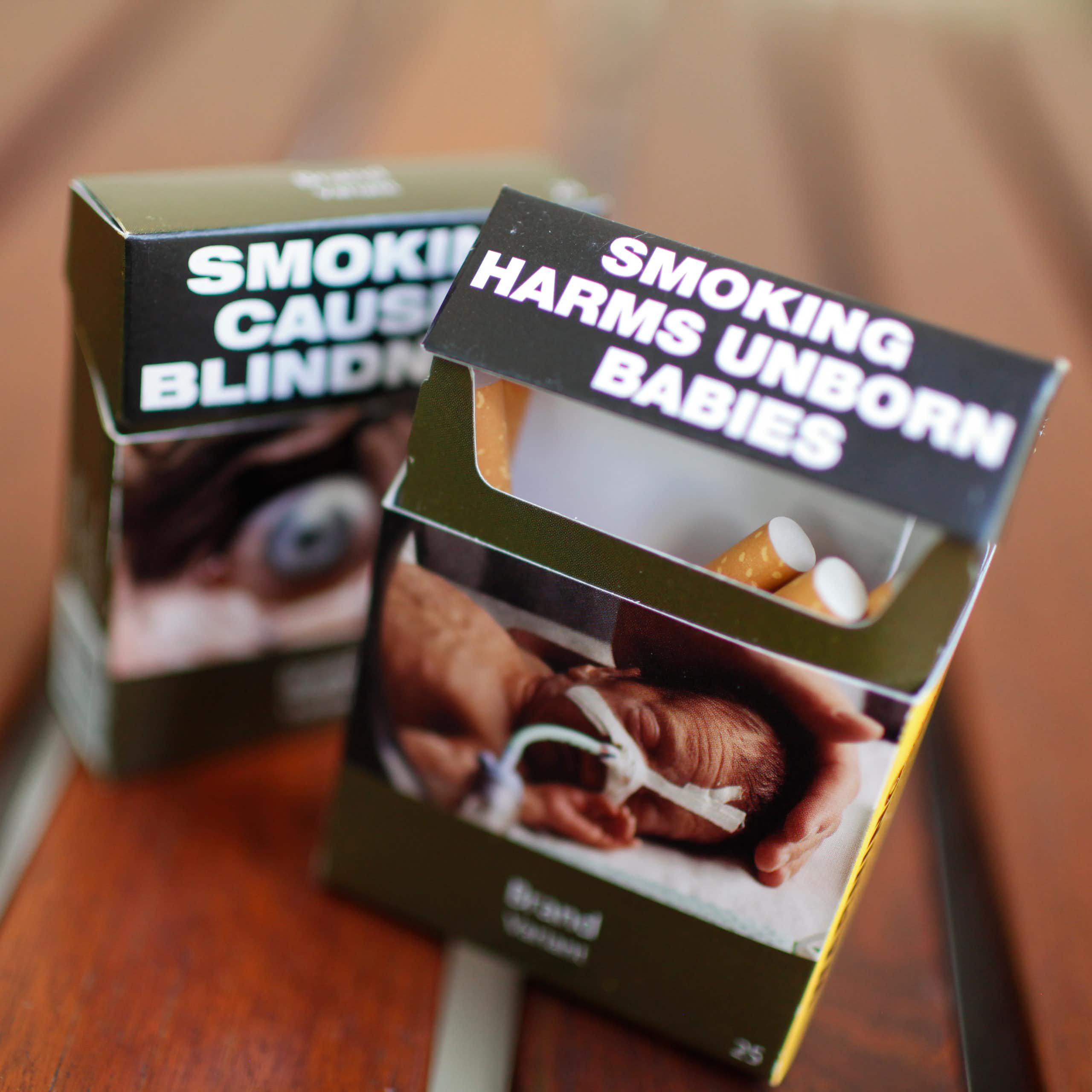 Two cigarette packs with plain packaging health warnings